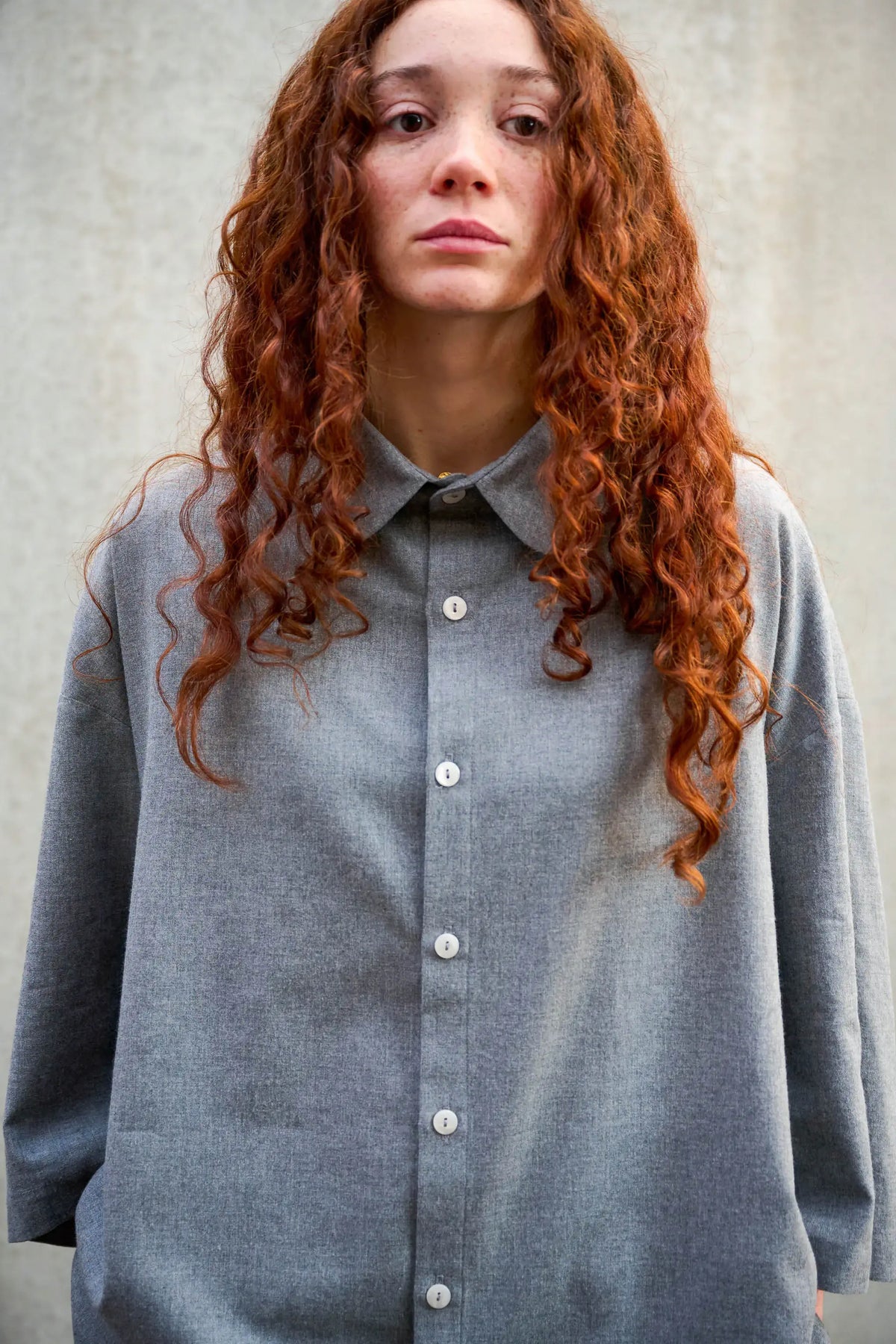 Chemise oversize arrondie de la marque Aïdama, modèle Marui en coton gratté gris clair. Porté par une mannequin femme et vue de face.