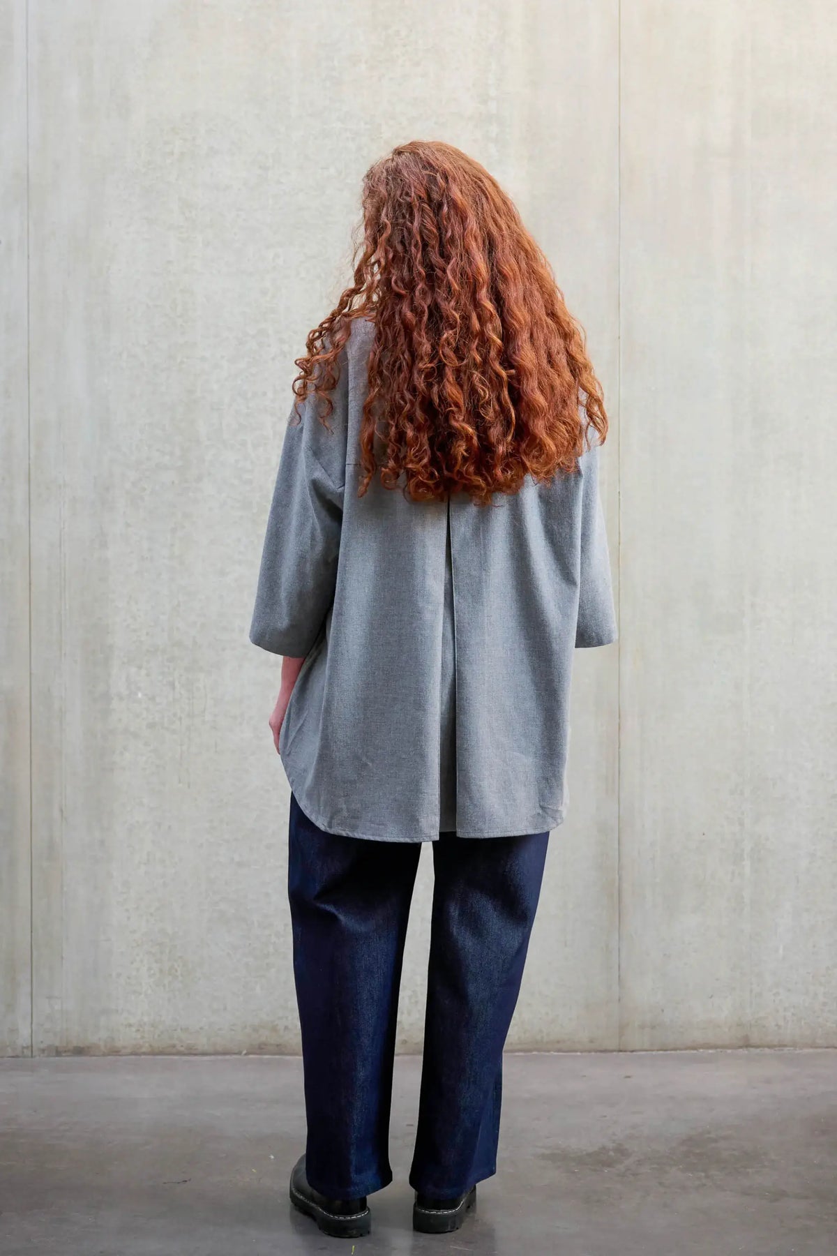 Chemise oversize arrondie de la marque Aïdama, modèle Marui en coton gratté gris clair. Porté par une mannequin femme et vue de dos.