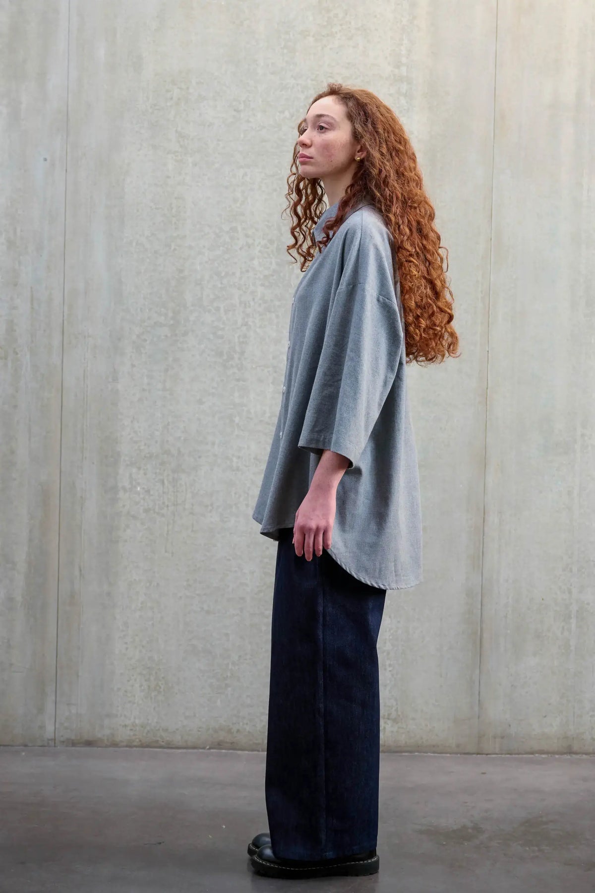 Chemise oversize arrondie de la marque Aïdama, modèle Marui en coton gratté gris clair. Porté par une mannequin femme et vue de profil.