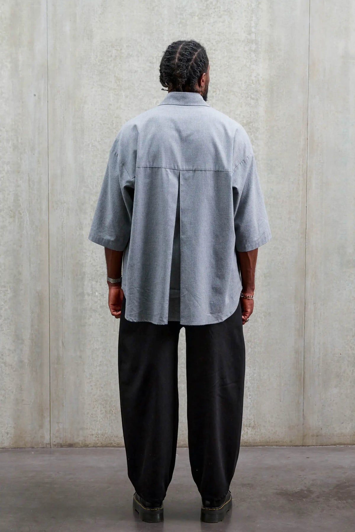 Chemise oversize arrondie de la marque Aïdama, modèle Marui en coton gratté gris clair. Porté par un mannequin homme et vue de dos.