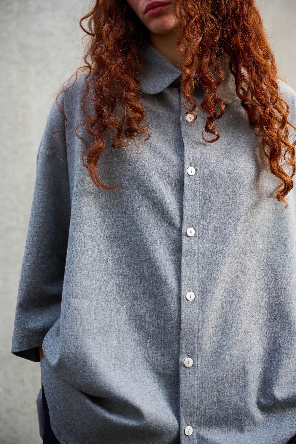 Chemise oversize arrondie de la marque Aïdama, modèle Marui en coton gratté gris clair. Porté par une mannequin femme et vue de face centrée sur le buste.