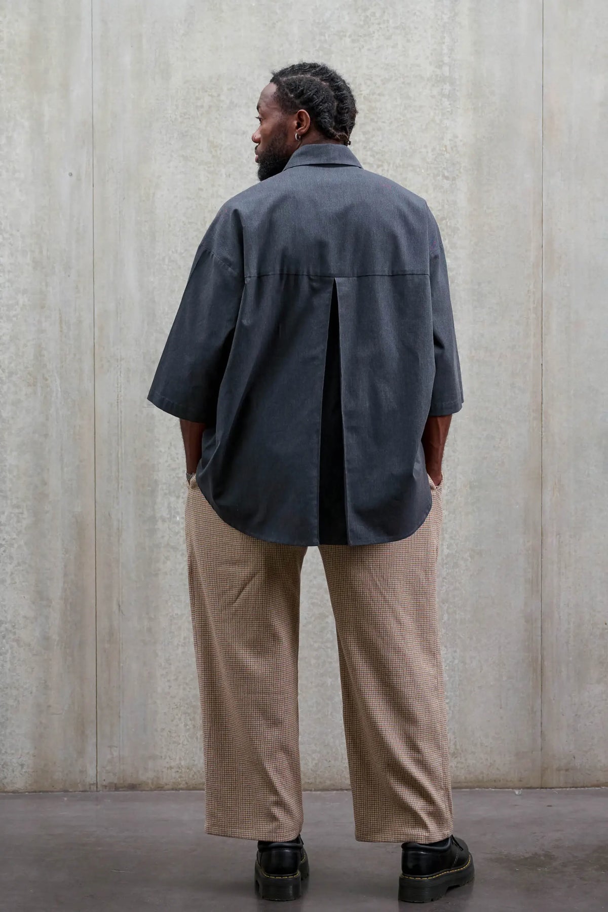 Chemise oversize arrondie de la marque Aïdama, modèle Marui en coton gratté gris foncé. Portée par un mannequin homme et vue de dos.