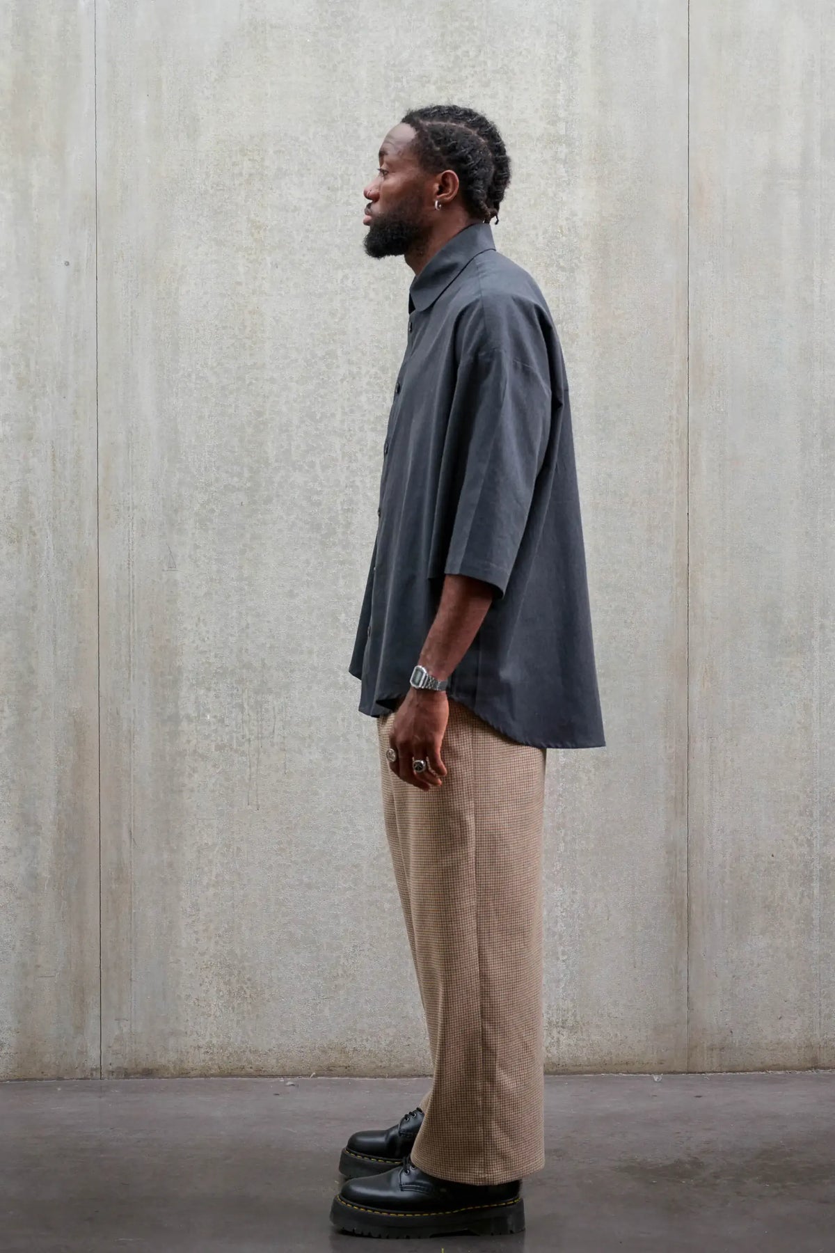 Chemise oversize arrondie de la marque Aïdama, modèle Marui en coton gratté gris foncé. Portée par un mannequin homme et vue de profil.