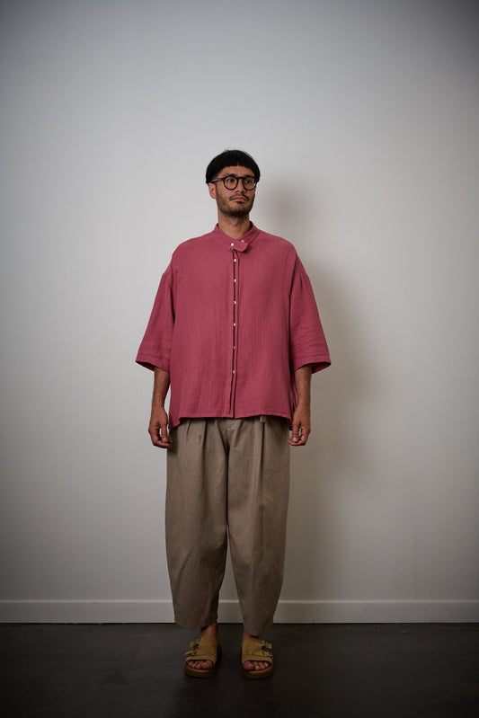 Chemise oversize à col officier de la marque aidama, modèle kita, coupe boxy en gaze de coton framboise. Portée par un mannequin homme et vu de face.