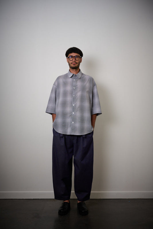 Chemise oversize à manches courtes et col club de la marque Aïdama, modèle Marui en popeline de coton à carreaux flous bleu-gris. Portée par un mannequin homme et vue de face.