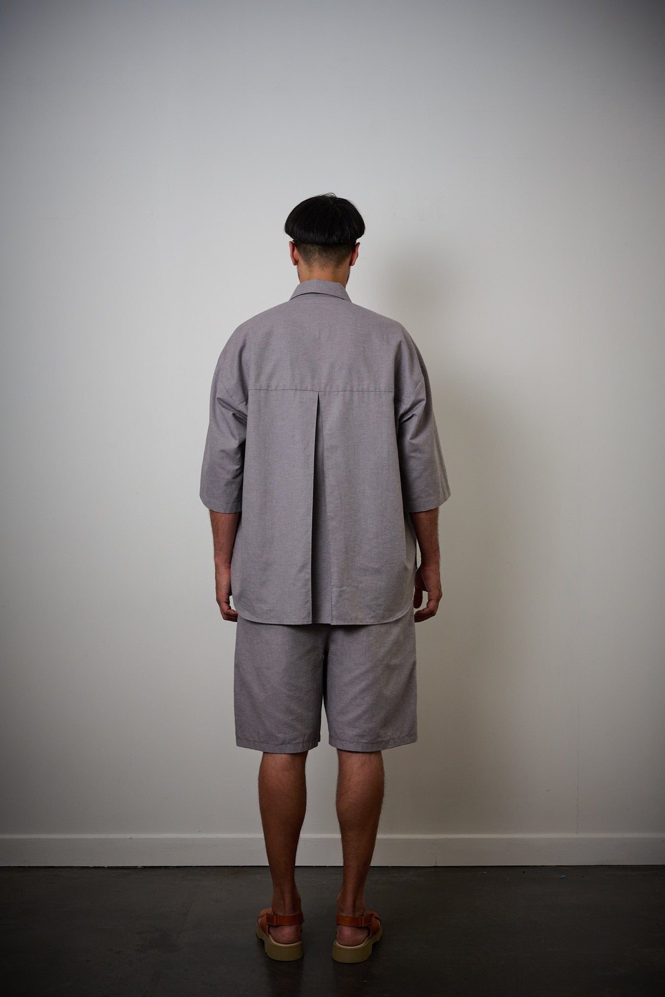 Chemise oversize à manches courtes et col club de la marque Aïdama, modèle Marui en coton lavande-gris. Portée par un mannequin homme et vue de dos.