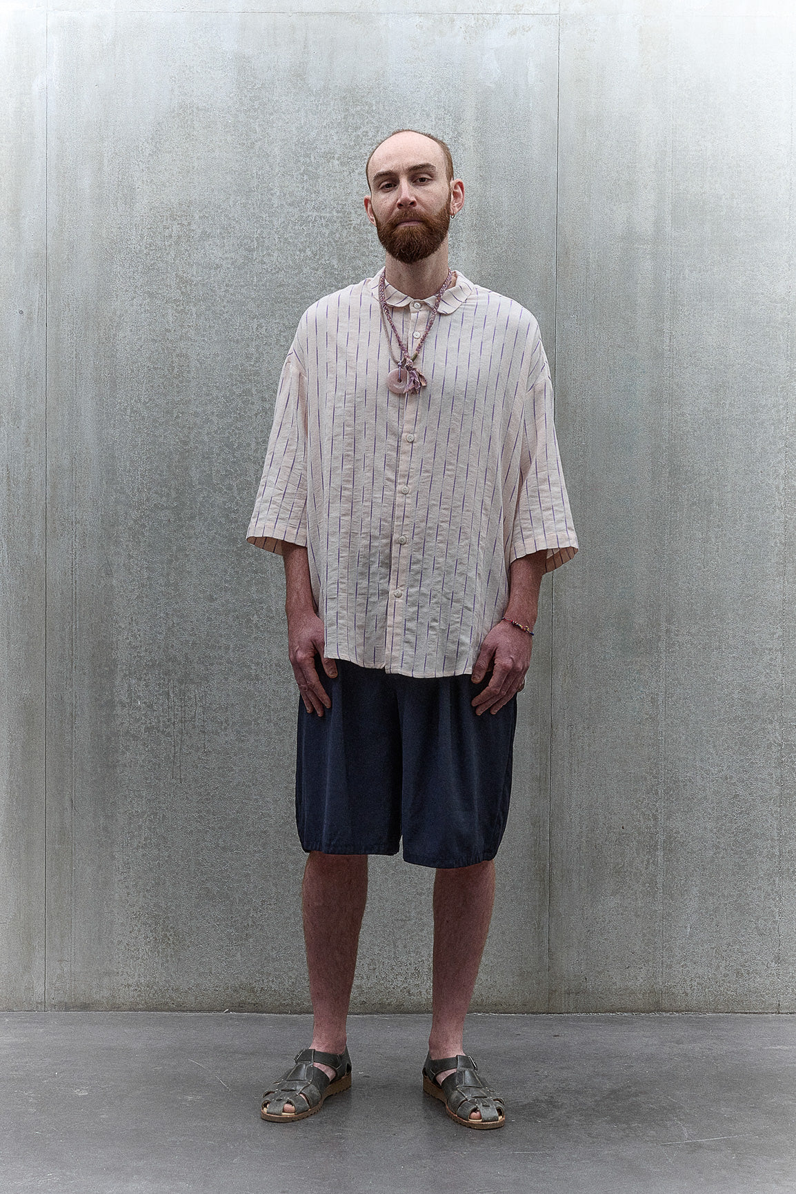 Chemise oversize à manches courtes et col club de la marque Aïdama, modèle Marui en coton rose à rayures violettes. Portée par un mannequin homme et vue de face.