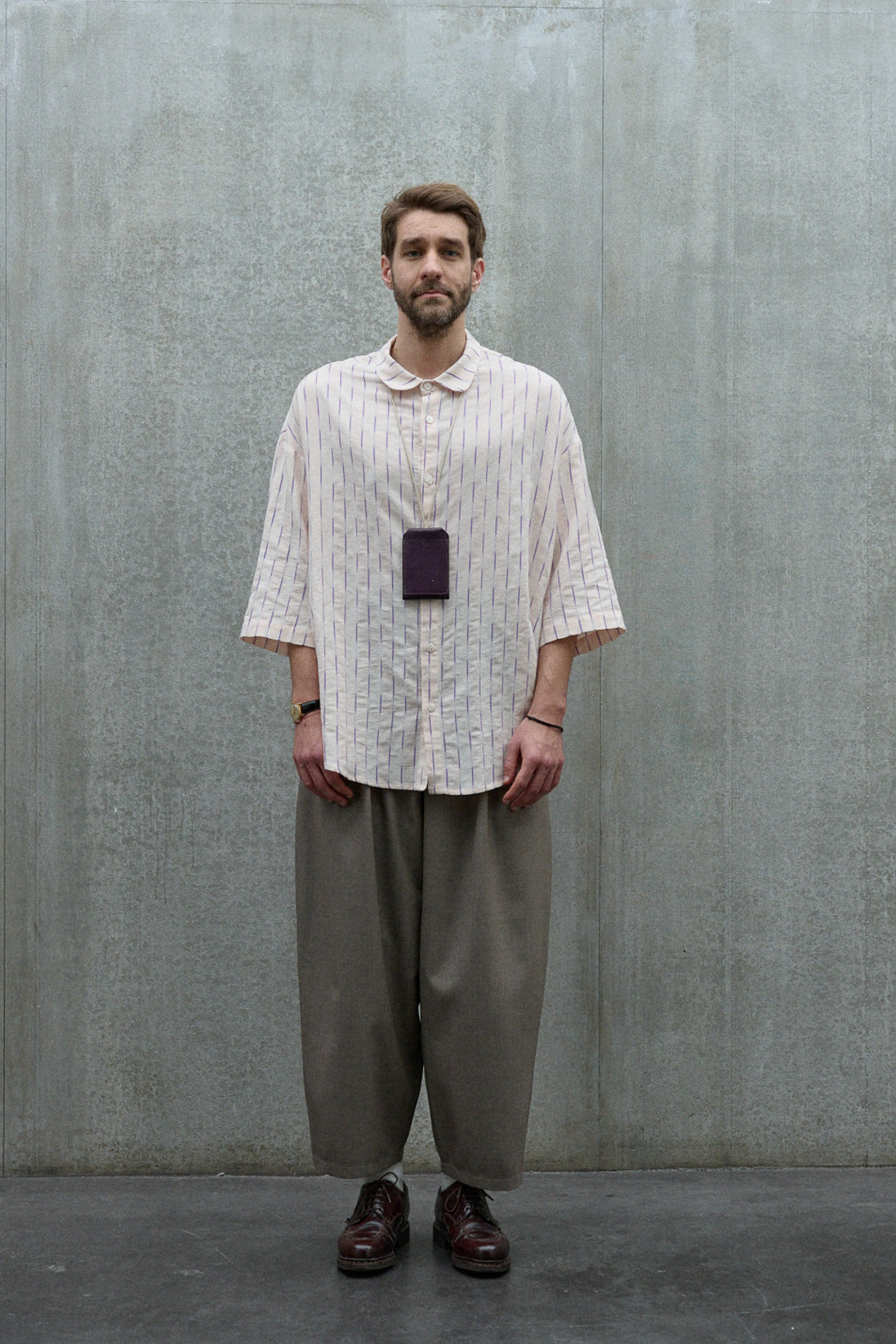 Chemise oversize à manches courtes et col club de la marque Aïdama, modèle Marui en coton rose à rayures violettes. Portée par un mannequin homme et vue de face.