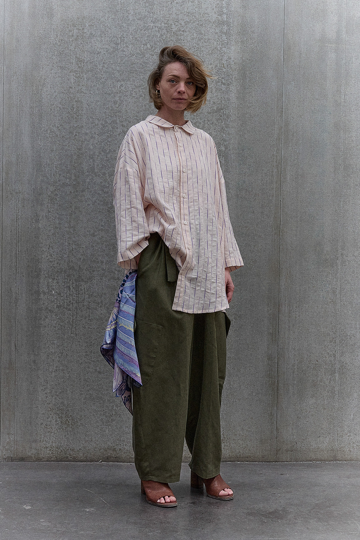 Chemise oversize à manches courtes et col officier de la marque Aïdama, modèle Kita en coton coton rose à rayures violettes. Portée par une mannequin femme et vue de face.