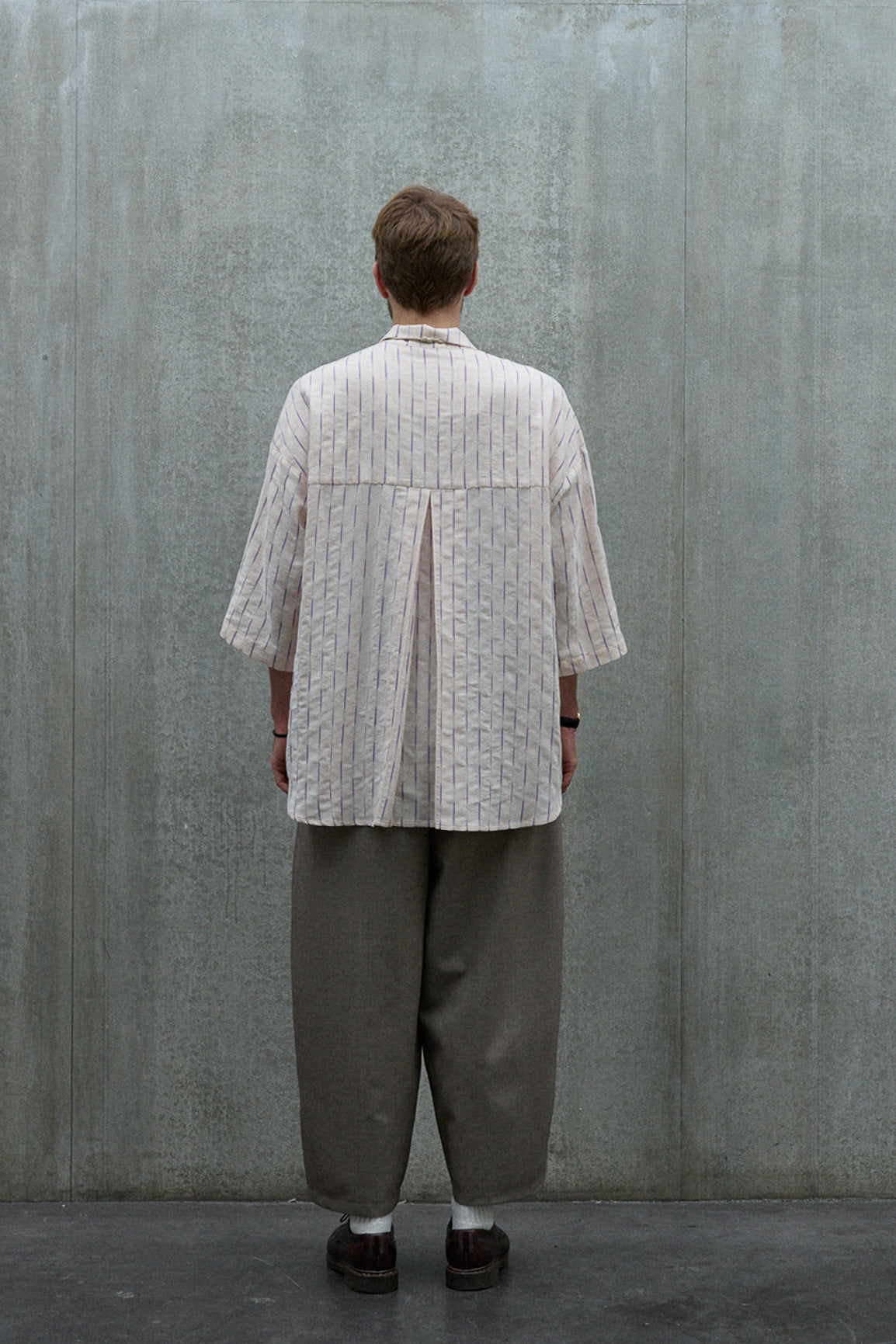 Chemise oversize à manches courtes et col club de la marque Aïdama, modèle Marui en coton rose à rayures violettes. Portée par un mannequin homme et vue de dos.