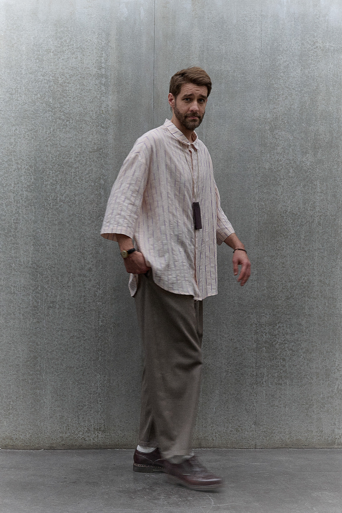 Chemise oversize à manches courtes et col club de la marque Aïdama, modèle Marui en coton rose à rayures violettes. Portée par un mannequin homme et vue de face.