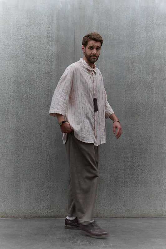 Chemise oversize à manches courtes et col club de la marque Aïdama, modèle Marui en coton rose à rayures violettes. Portée par un mannequin homme et vue de face.