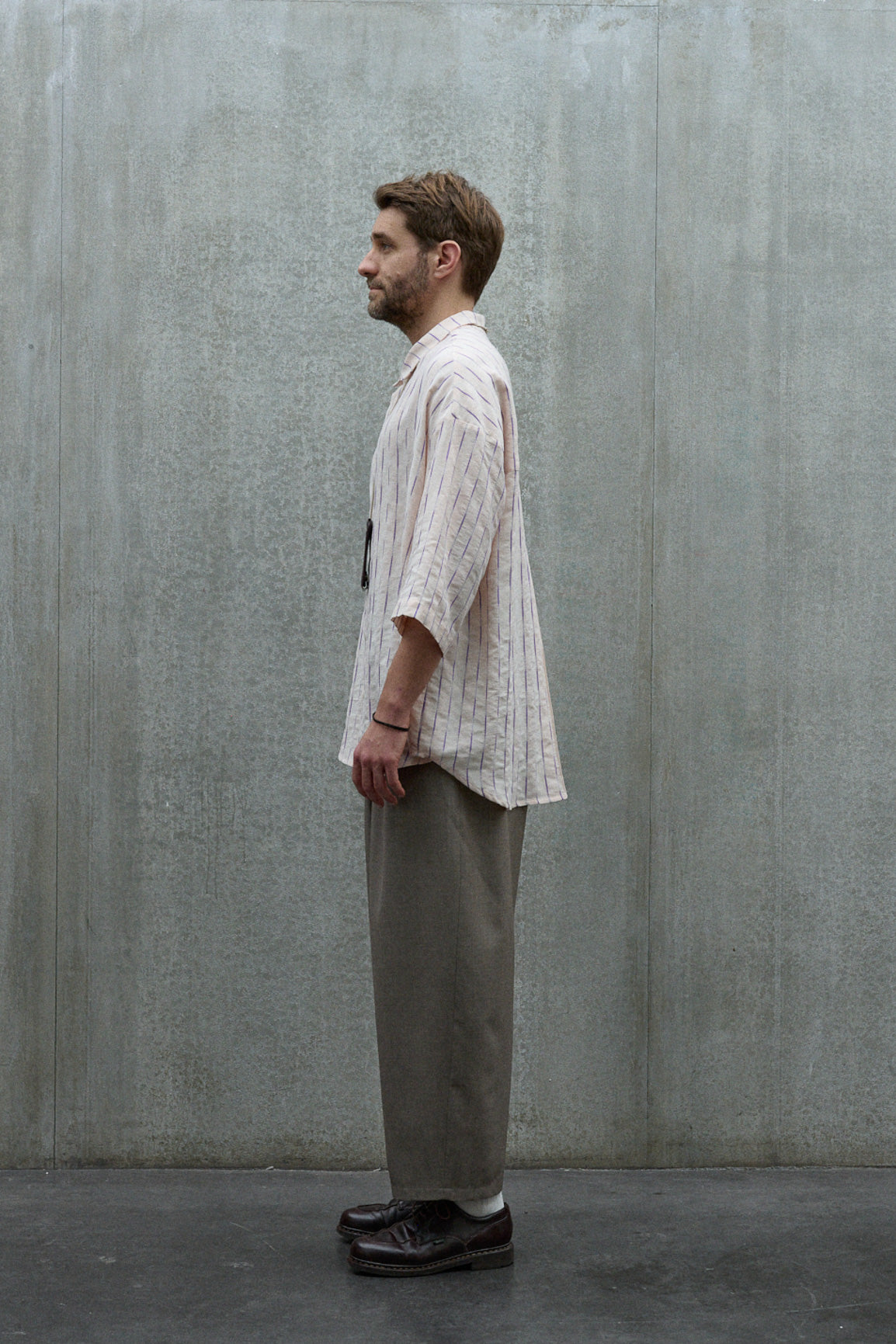 Chemise oversize à manches courtes et col club de la marque Aïdama, modèle Marui en coton rose à rayures violettes. Portée par un mannequin homme et vue de profil.