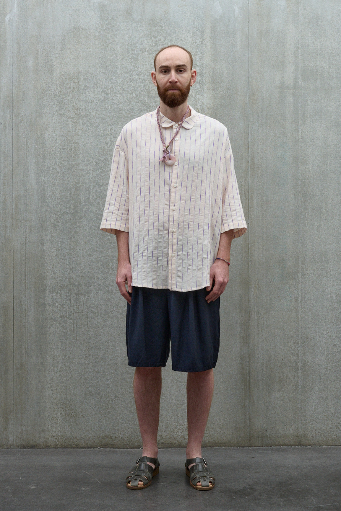 Chemise oversize à manches courtes et col club de la marque Aïdama, modèle Marui en coton rose à rayures violettes. Portée par un mannequin homme et vue de face. 