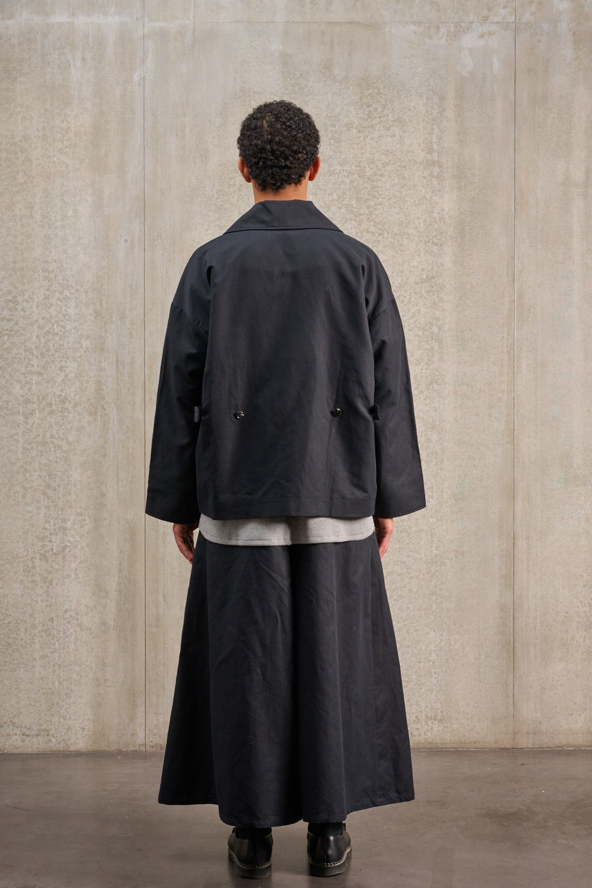 Jupe culotte oversize de la marque Aïdama, modèle Hakama en coton & lin noir. Porté par un mannequin homme et vu de dos.