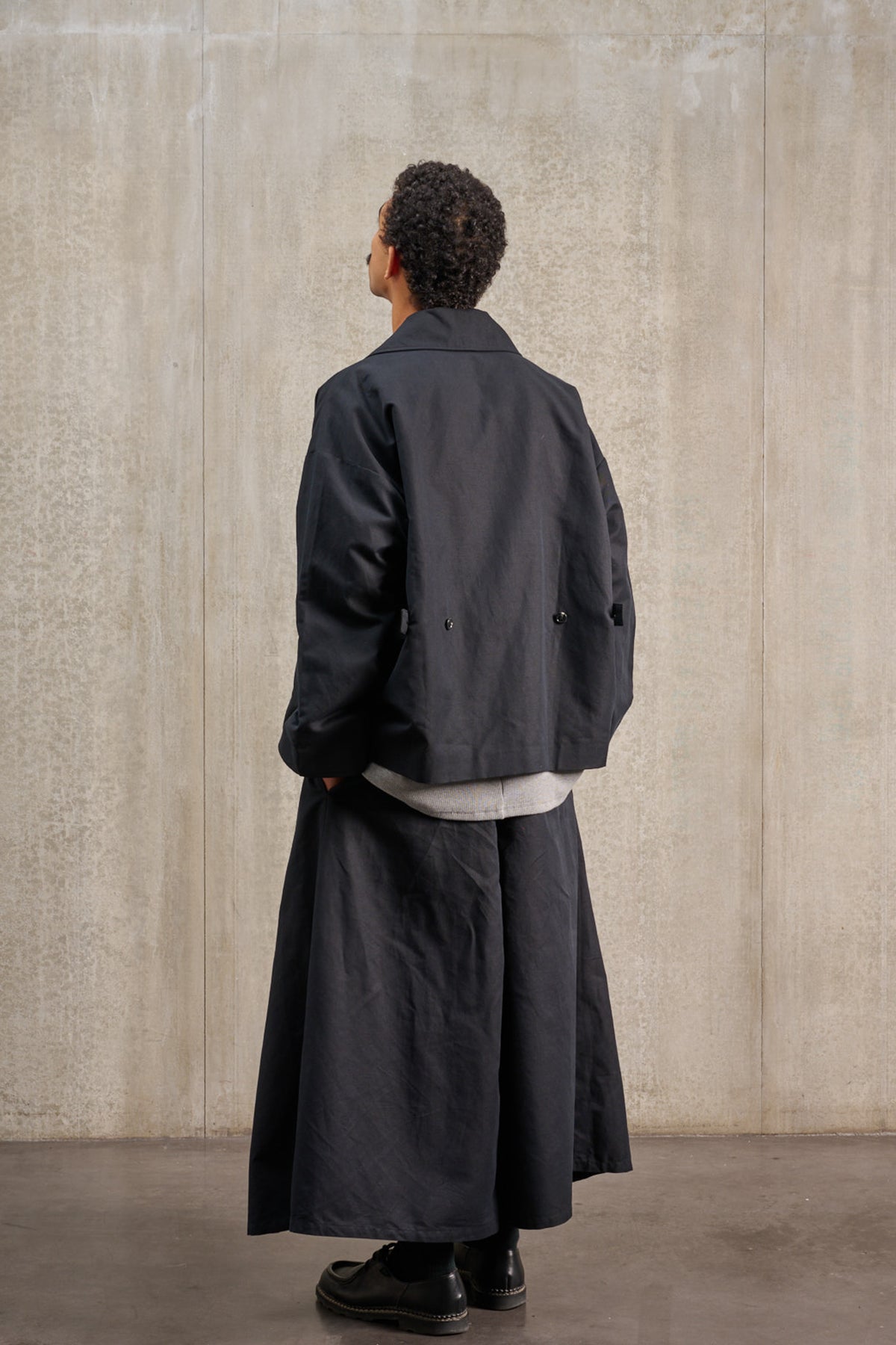 Jupe culotte oversize de la marque Aïdama, modèle Hakama en coton & lin noir. Porté par un mannequin homme et vu de dos.