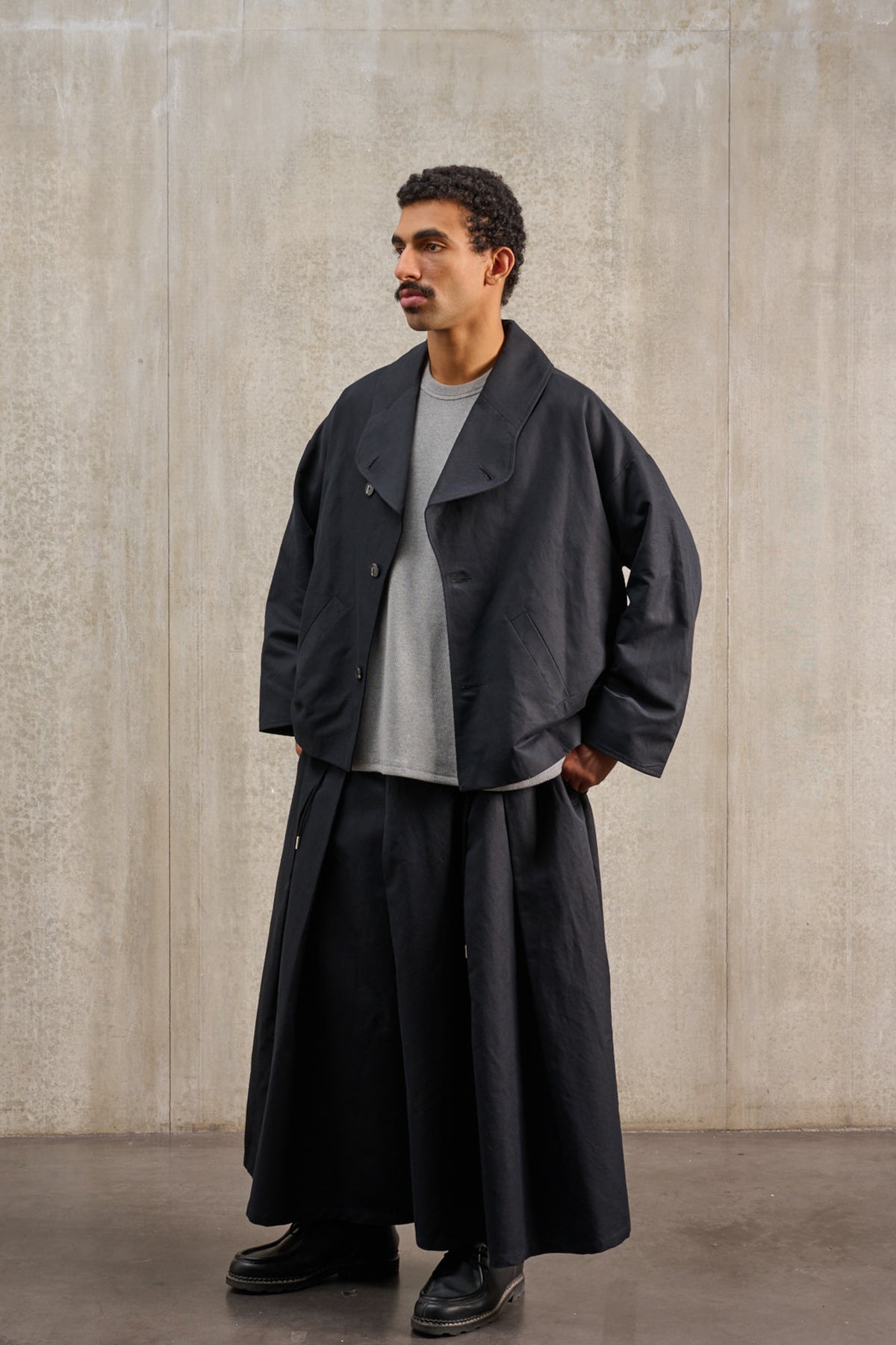 Jupe culotte oversize de la marque Aïdama, modèle Hakama en coton & lin noir. Porté par un mannequin homme et vu de trois quarts.