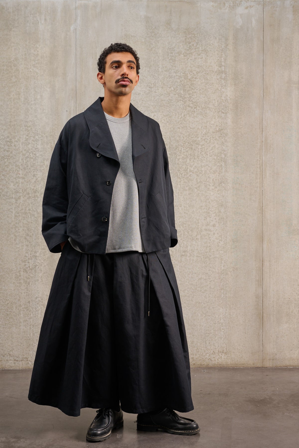 Jupe culotte oversize de la marque Aïdama, modèle Hakama en coton & lin noir. Porté par un mannequin homme et vu de face.