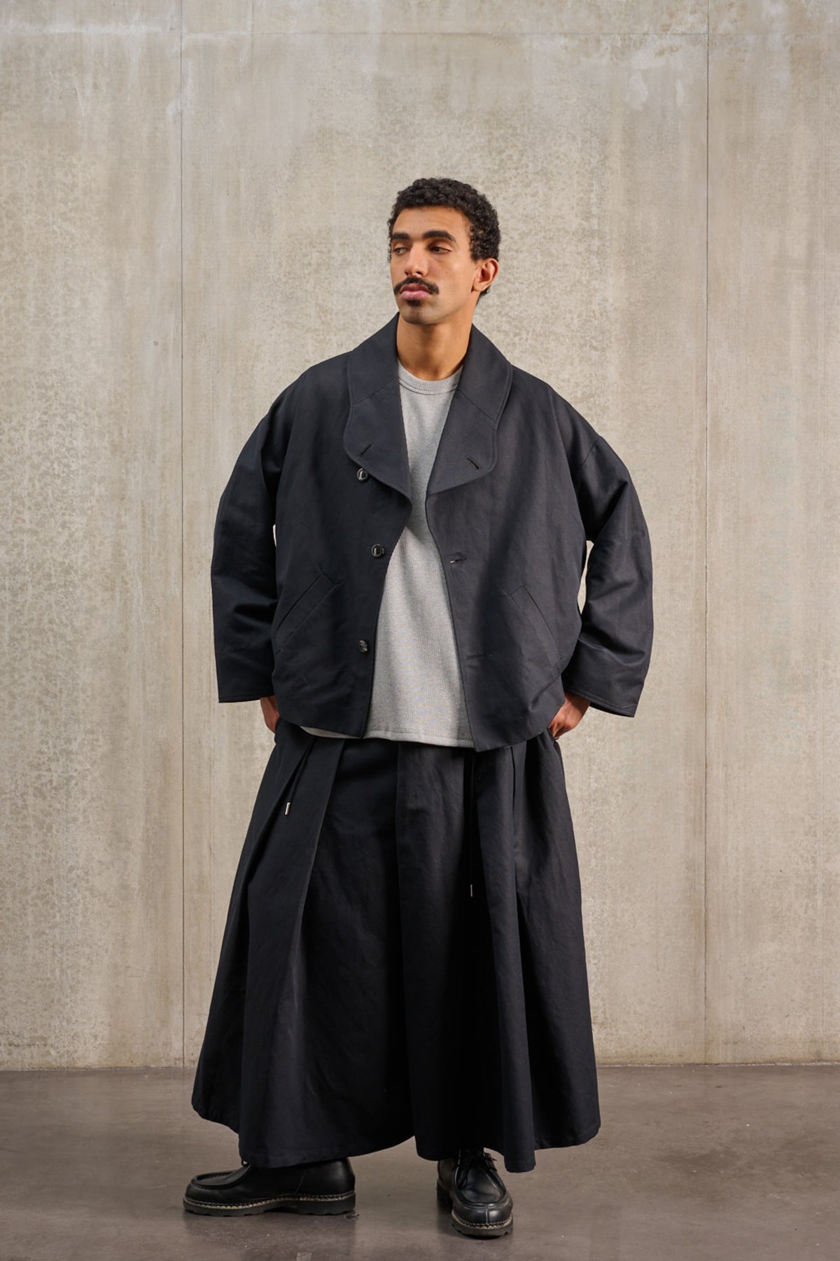 Jupe culotte oversize de la marque Aïdama, modèle Hakama en coton & lin noir. Porté par un mannequin homme et vu de face.
