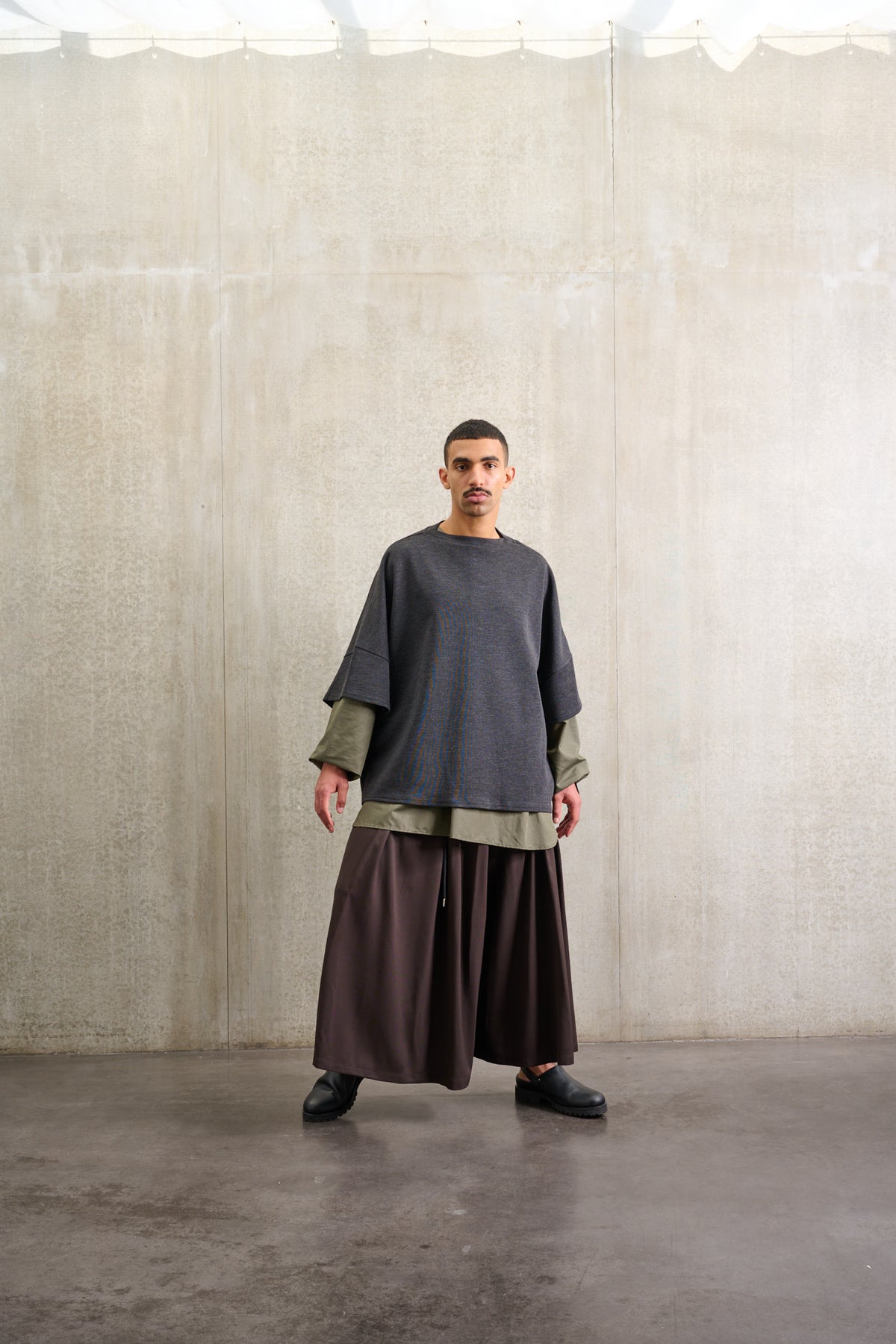 Jupe culotte oversize de la marque Aïdama, modèle Hakama en laine froide marron, portée par un modèle homme et vue de face.