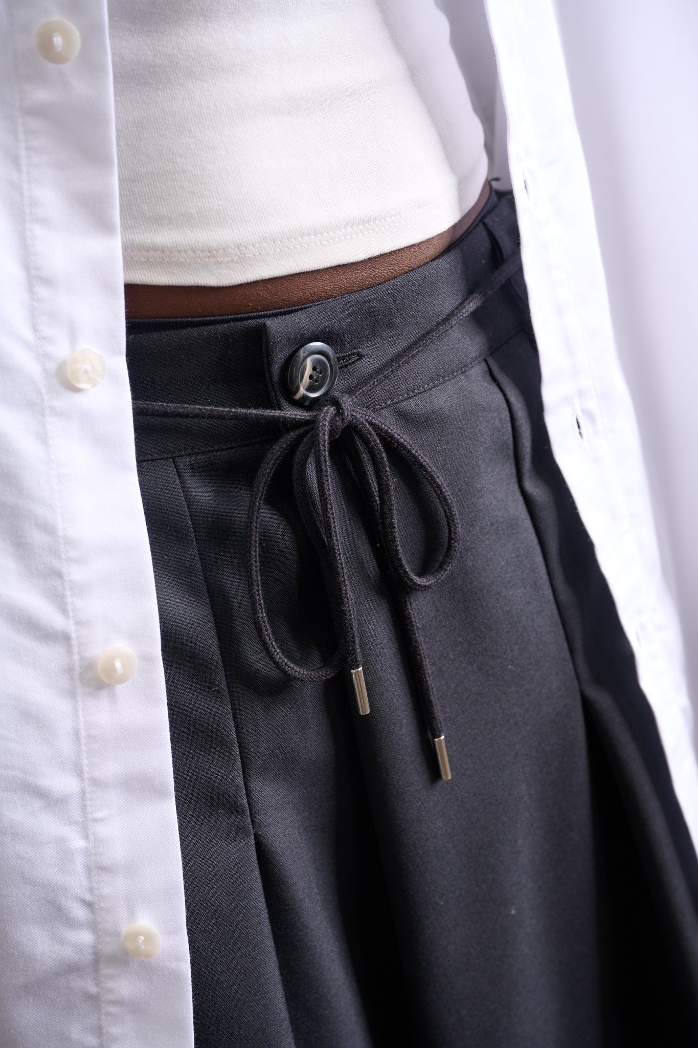 Jupe culotte oversize de la marque Aïdama, modèle Hakama en laine froide noire, portée par un modèle femme et vue zoomée sur le cordon de serrage.