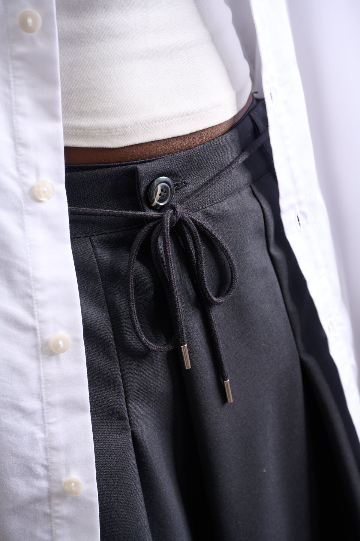 Jupe culotte oversize de la marque Aïdama, modèle Hakama en laine froide noire, portée par un modèle femme et vue zoomée sur le cordon de serrage.