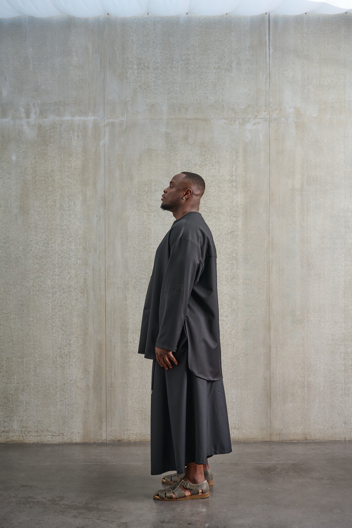Jupe culotte oversize de la marque Aïdama, modèle Hakama en laine froide noire, portée par un modèle homme et vue de profil