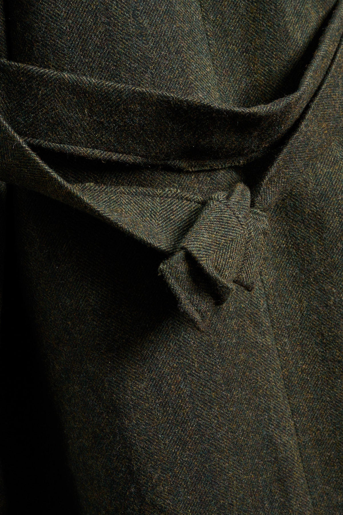 Manteau oversize à manches dolmans de la marque Aïdama, modèle Tanzen en laine, vert à motif chevrons. Zoom sur le tissu et la ceinture nouée dans le dos.