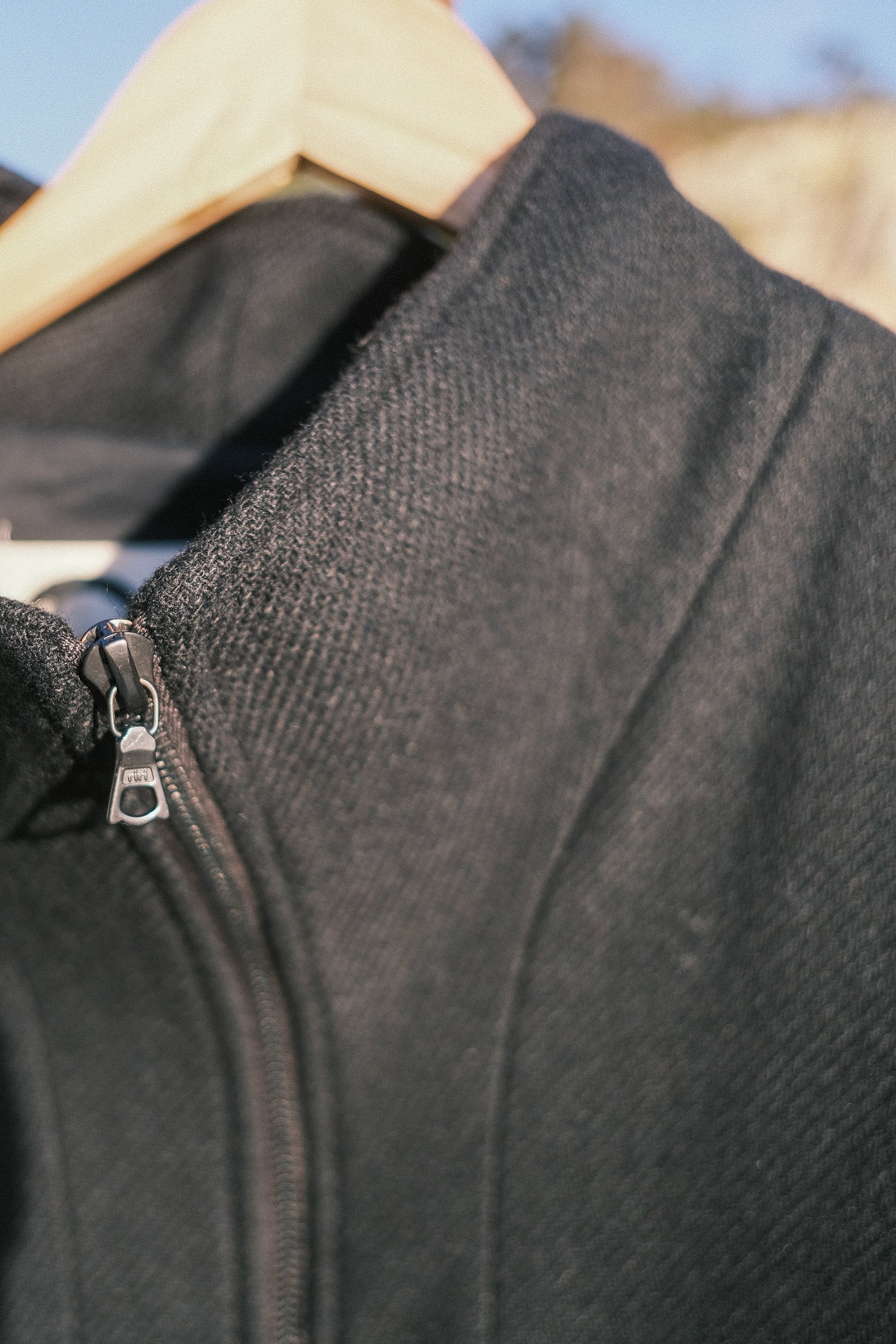 Manteau long à manches dolmans de la marque Aïdama, modèle Tanzen en laine noire. Vu zoomé sur le col.