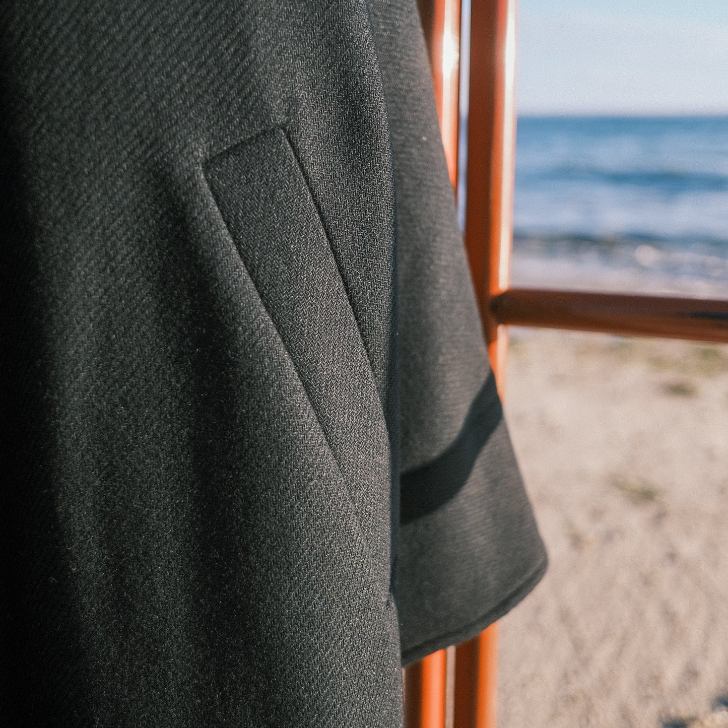 Manteau long à manches dolmans de la marque Aïdama, modèle Tanzen en laine noire. Vue zoomée sur la poche.