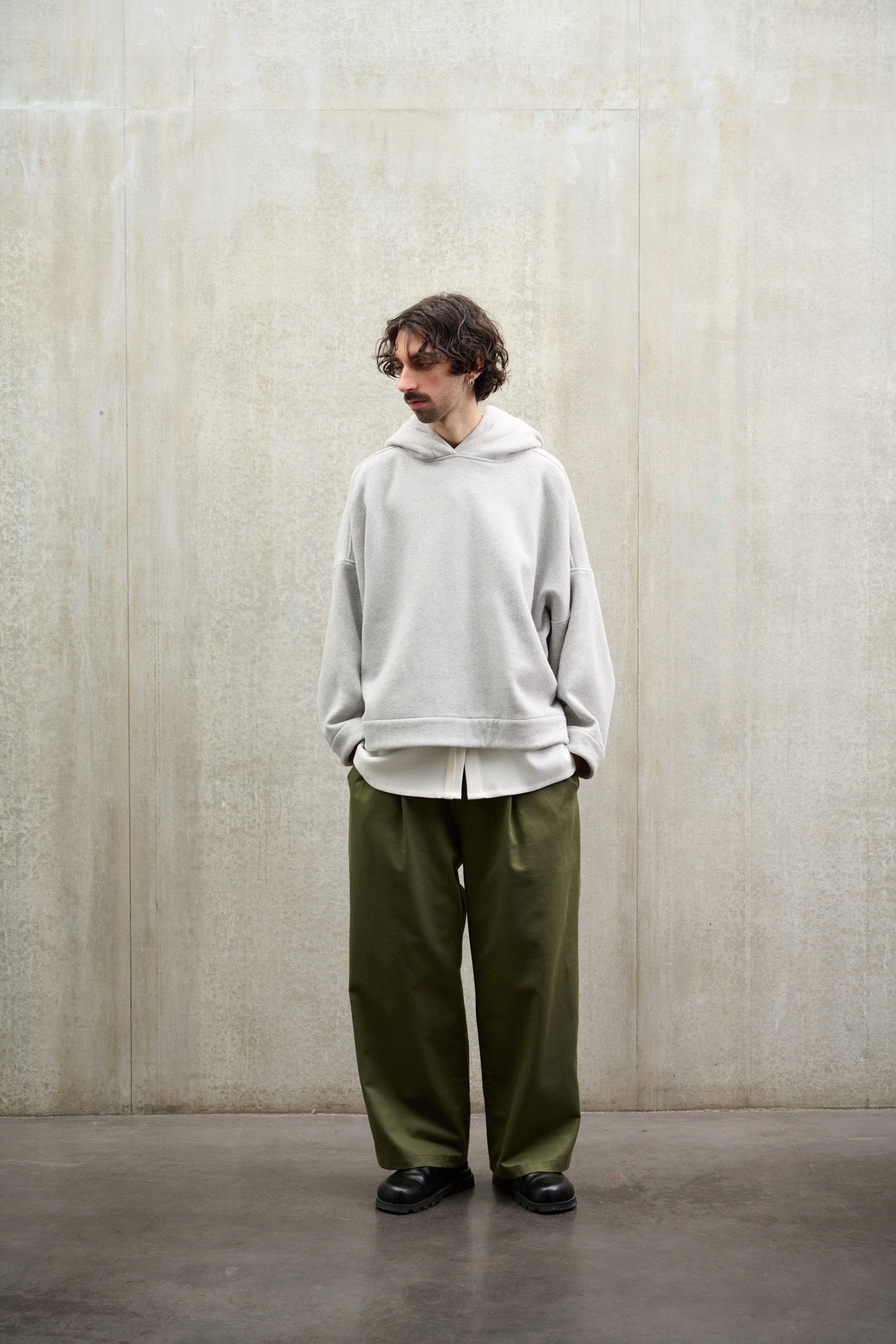 Pantalon droit à coupe ample, avec sangles de réglages de la marque  Aïdama en coton vert, porté par un mannequin homme et vu de face.