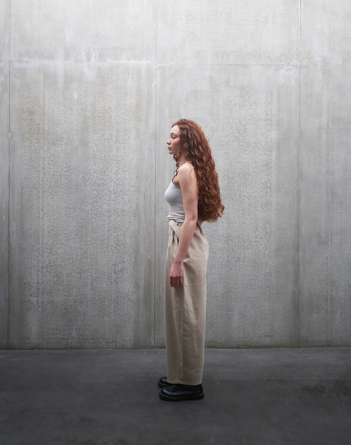Pantalon circulaire Aïdama, coupe ballon en coton beige. Porté par une mannequin femme et vu de profil.