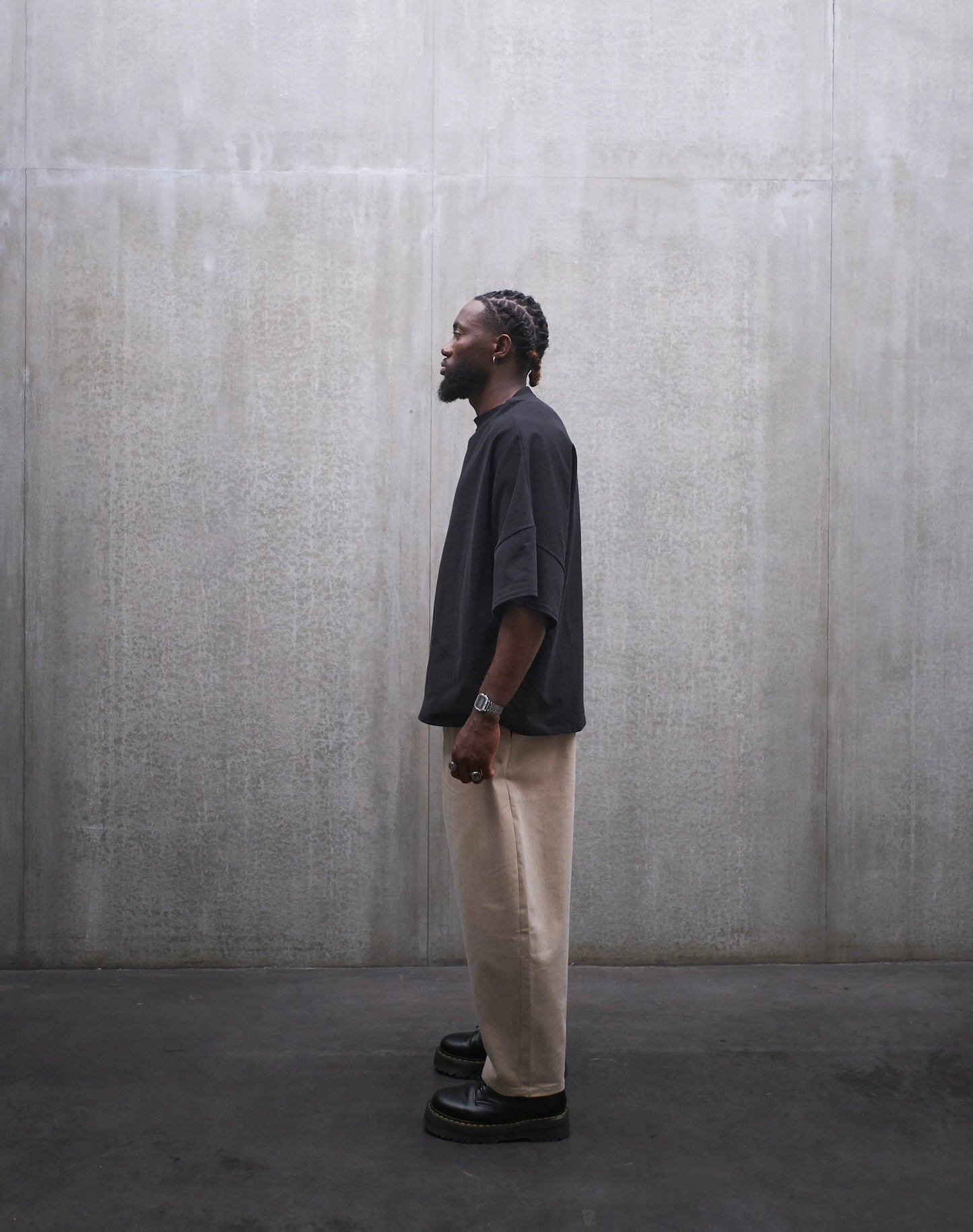 Pantalon circulaire Aïdama, coupe ballon en coton beige. Porté par un mannequin homme et vu de profil.