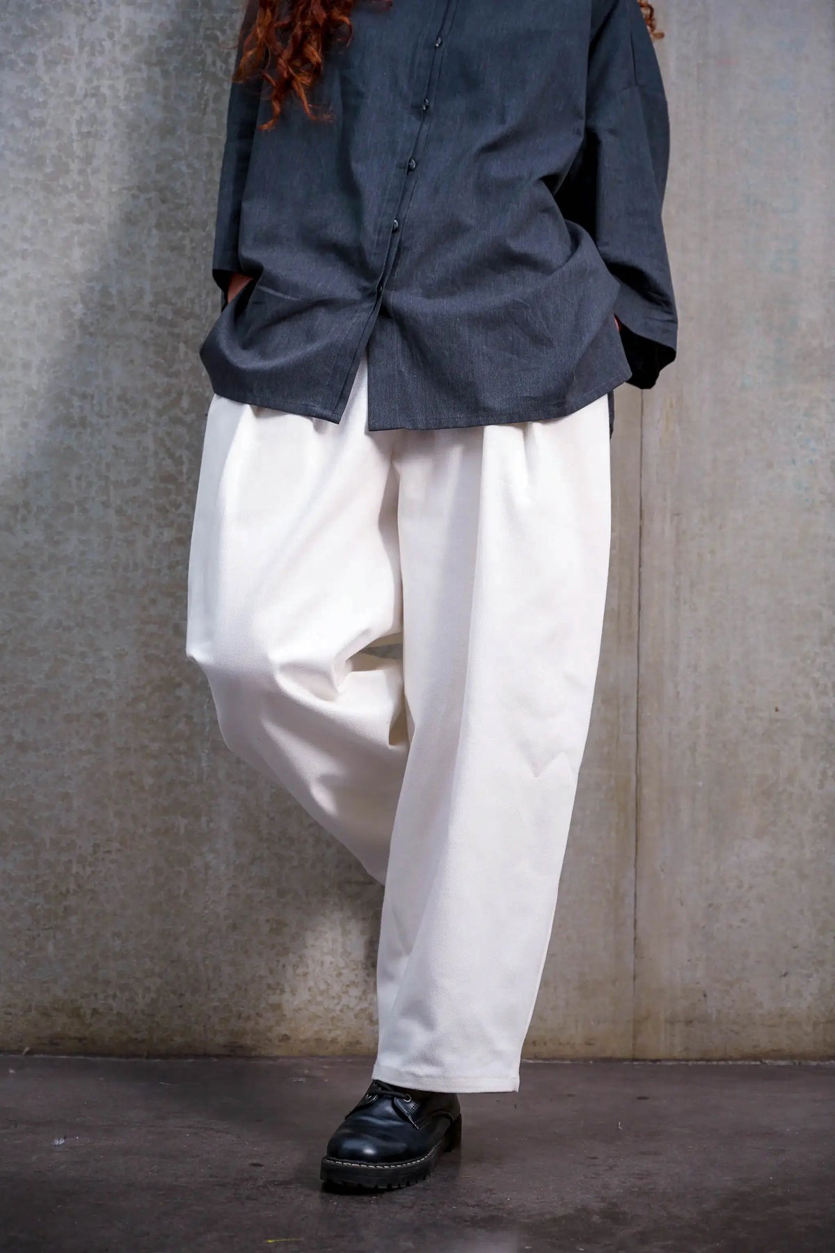 Pantalon circulaire unisexe de la marque Aïdama, coupe ballon en sergé de coton blanc. Porté par une mannequin femme et vu zoomé sur les jambes.