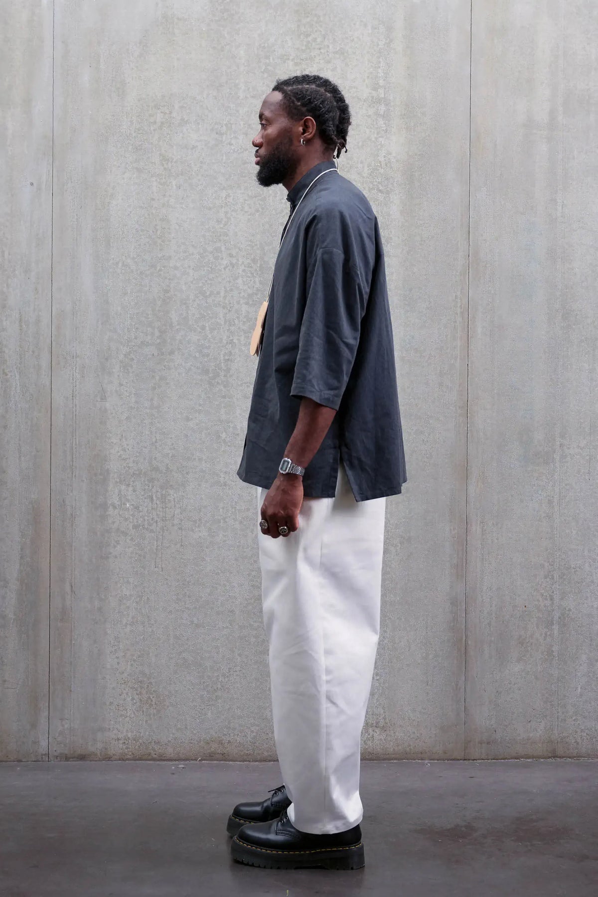Pantalon circulaire unisexe de la marque Aïdama, coupe ballon en sergé de coton blanc. Porté par un mannequin homme et vu de profil.