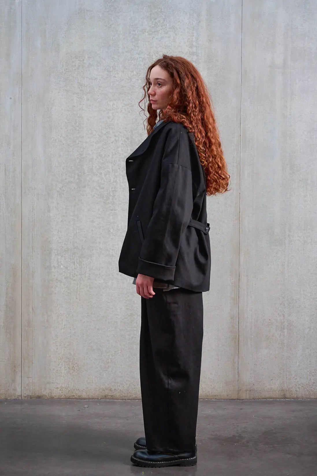 Pantalon circulaire unisexe de la marque Aïdama, coupe ballon en sergé de coton noir. Porté par une mannequin femme et vu de profil.