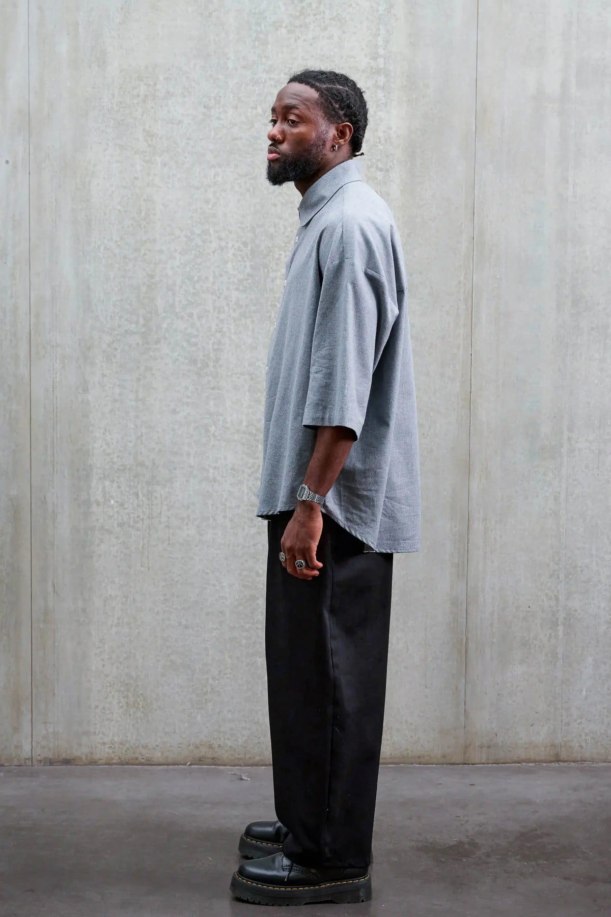 Pantalon circulaire unisexe de la marque Aïdama, coupe ballon en sergé de coton noir. Porté par un mannequin homme et vu de profil.