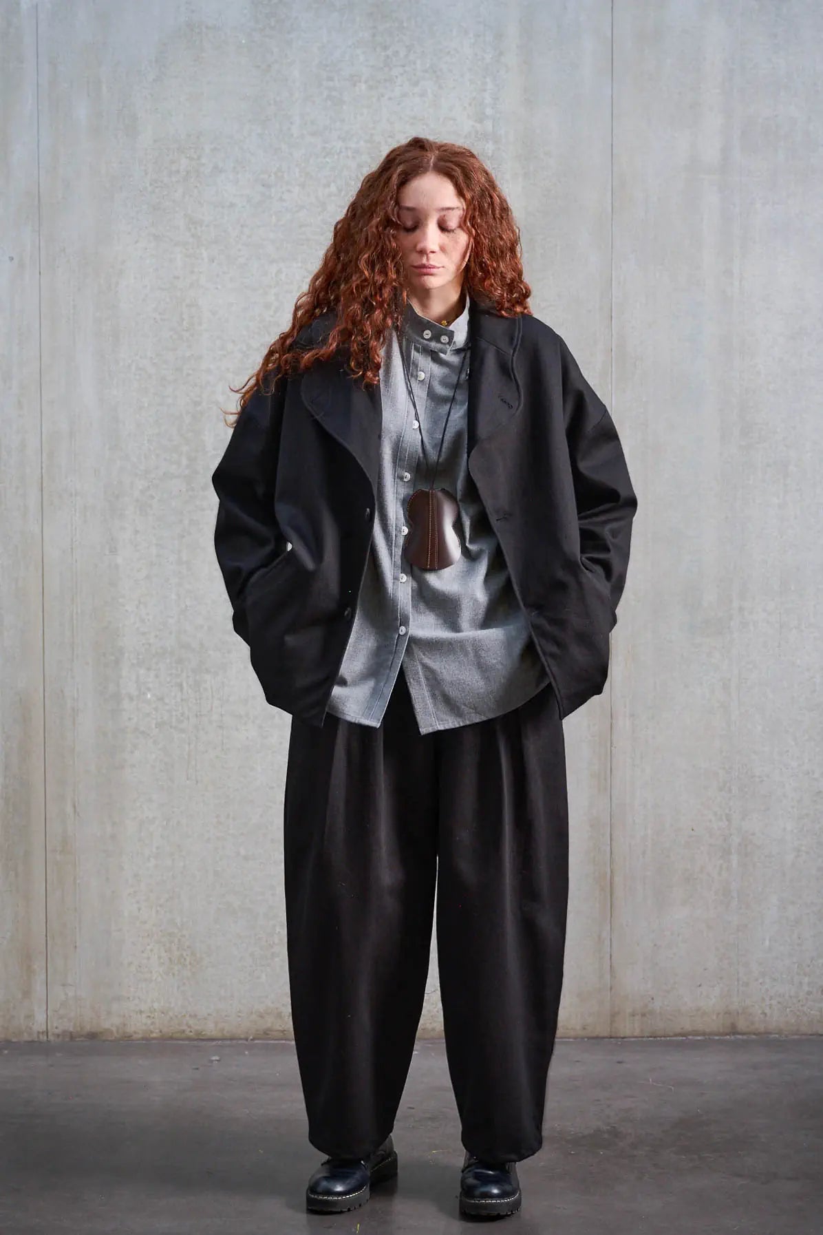 Pantalon circulaire unisexe de la marque Aïdama, coupe ballon en sergé de coton noir. Porté par une mannequin femme et vu de face.