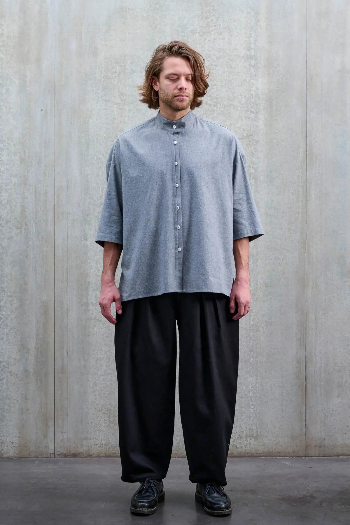 Pantalon circulaire unisexe de la marque Aïdama, coupe ballon en sergé de coton noir. Porté par un mannequin homme et vu de face.