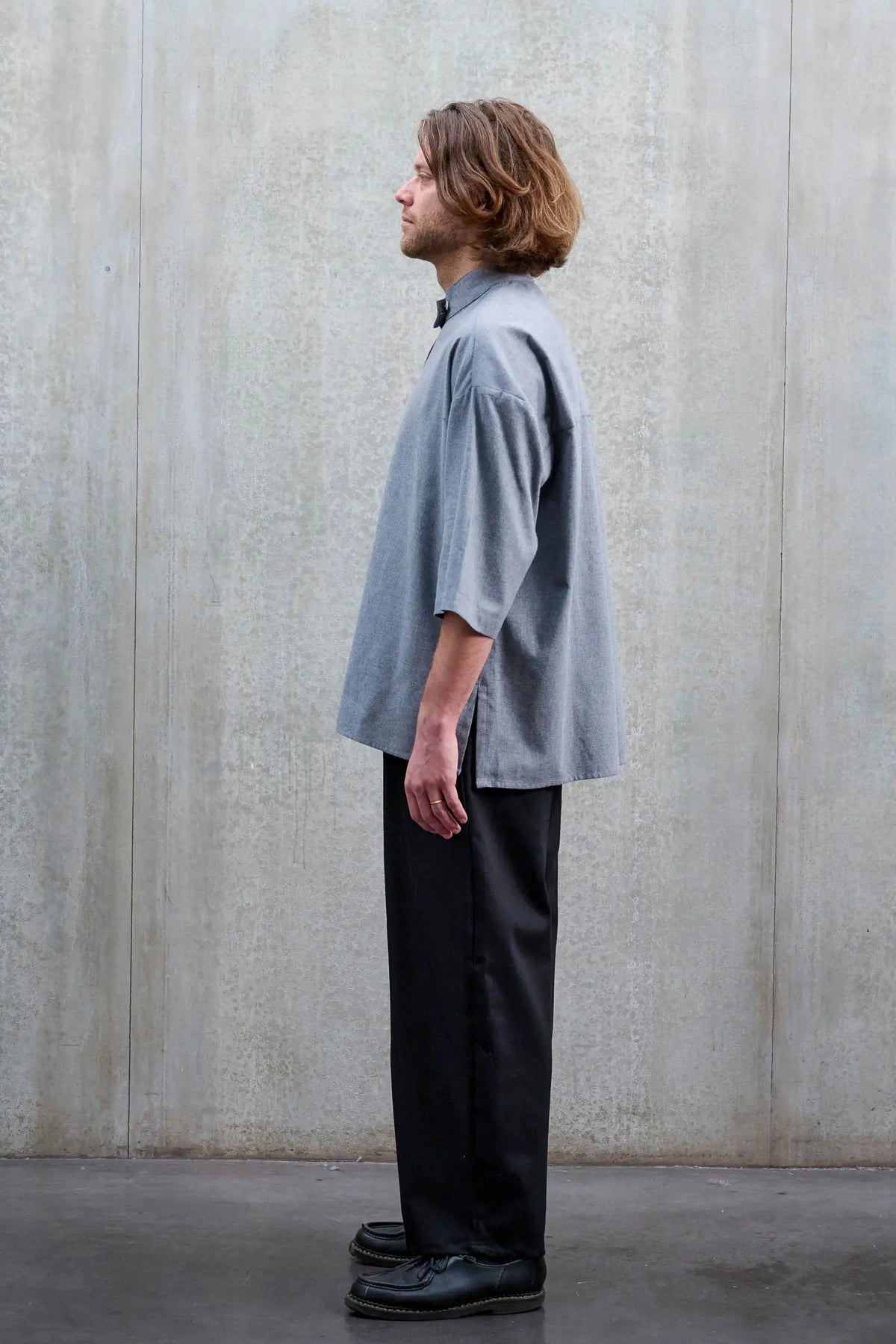 Pantalon circulaire unisexe de la marque Aïdama, coupe ballon en sergé de coton noir. Porté par un mannequin homme et vu de profil.