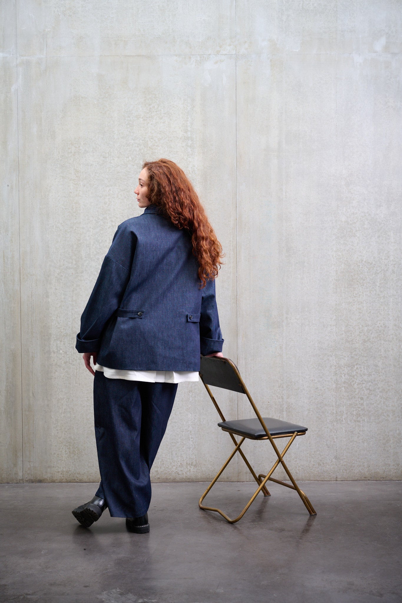 Pantalon circulaire Aïdama coupe ballon en denim brut. Porté par une mannequin femme et vu de dos.