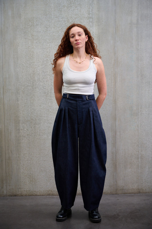 Pantalon circulaire Aïdama coupe ballon en denim brut. Porté par une mannequin femme et vue de face.