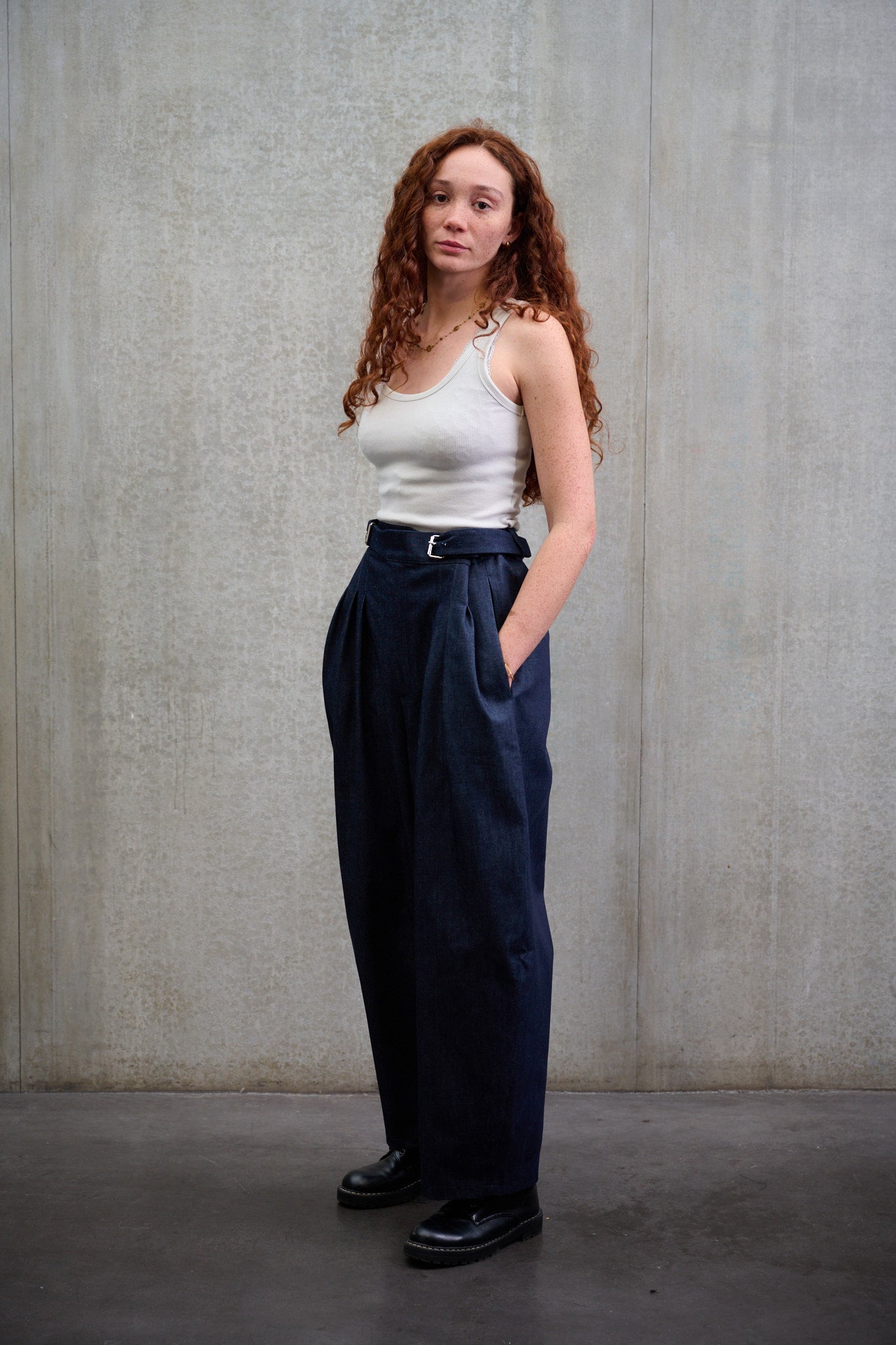 Pantalon circulaire Aïdama coupe ballon en denim brut. Porté par une mannequin femme et vu de trois quarts.