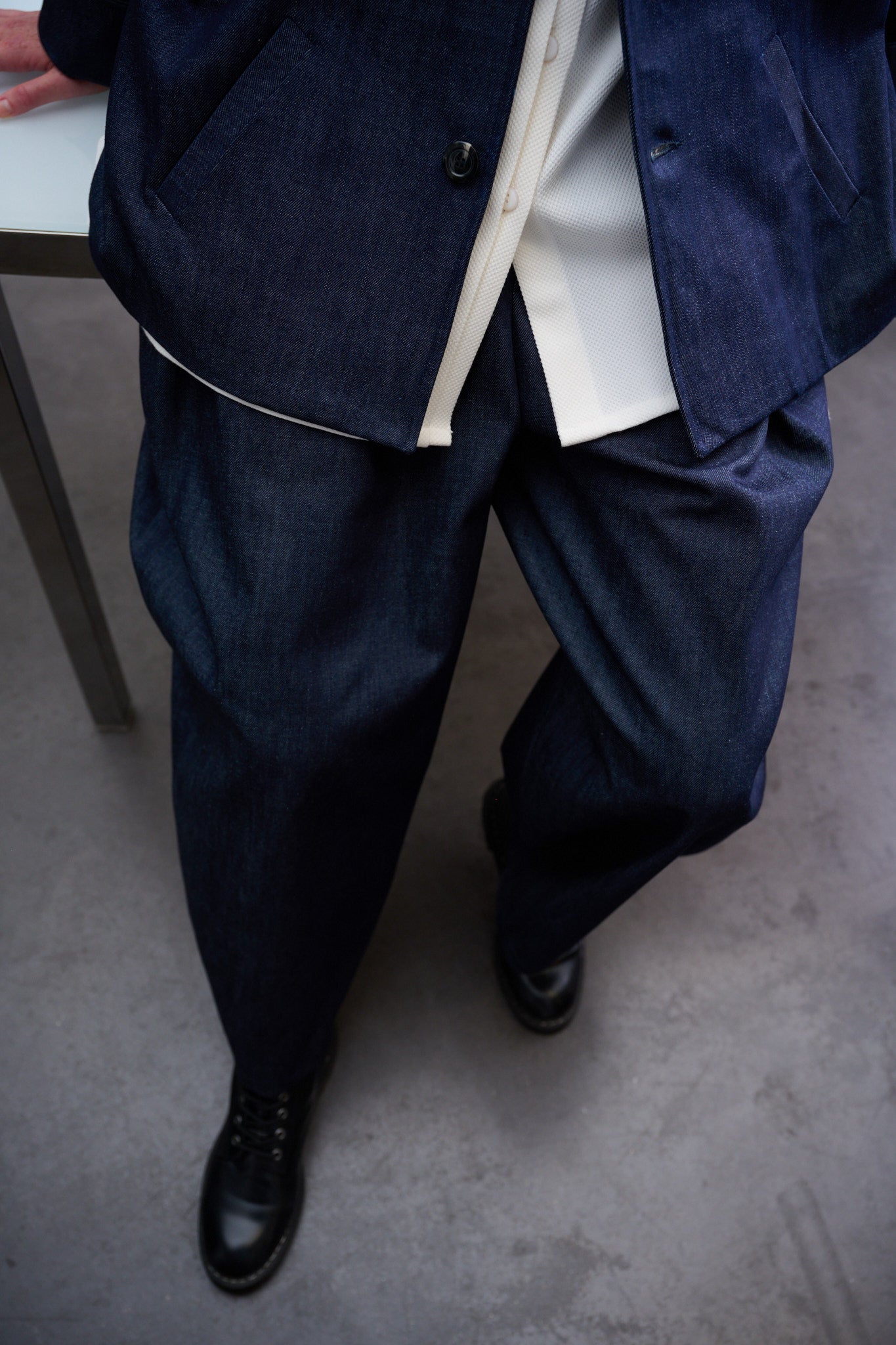 Pantalon circulaire Aïdama, coupe ballon en denim brut. Porté par une mannequin femme, vu de face et zoomé.