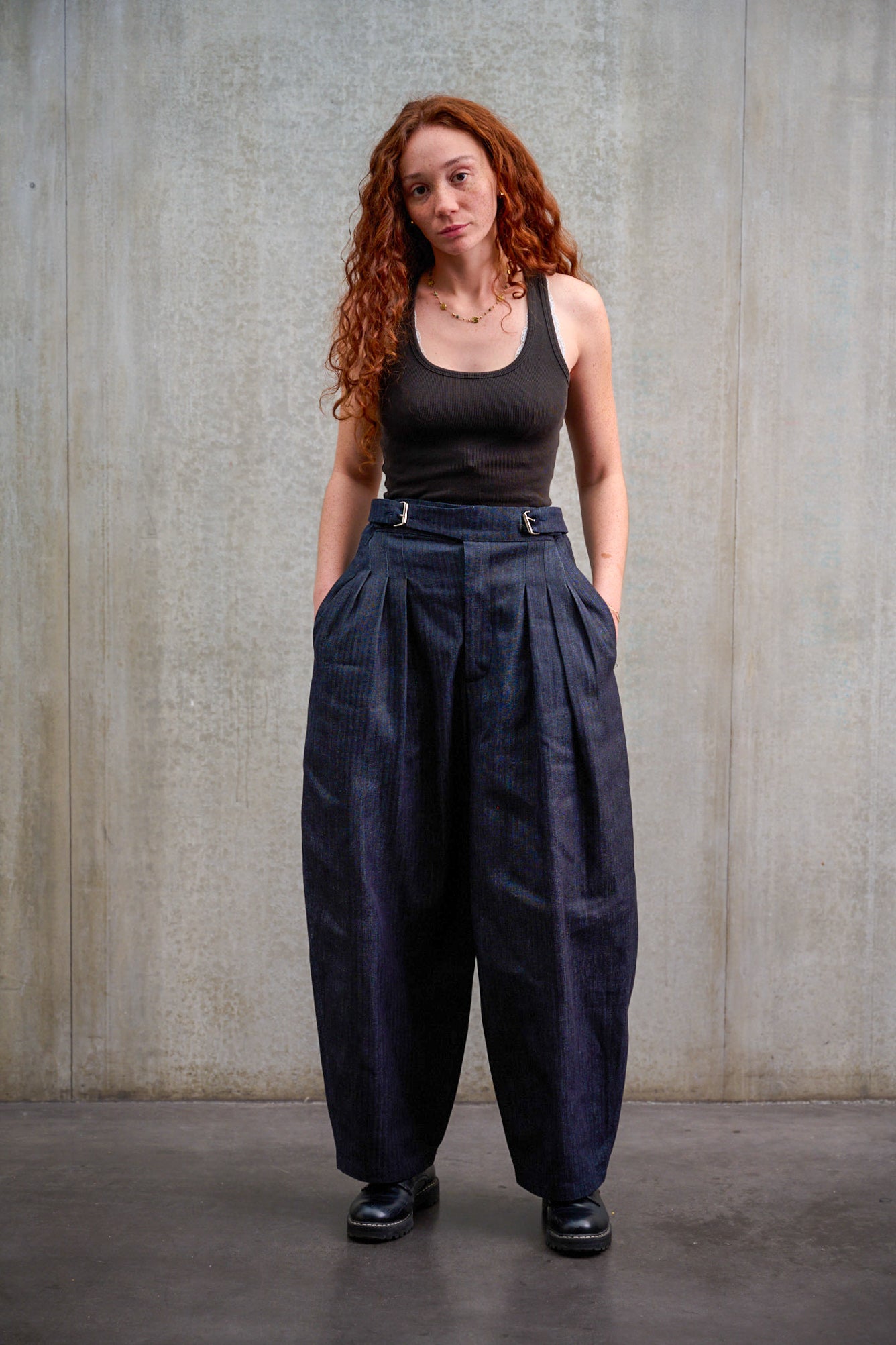 Pantalon circulaire Aïdama, coupe ballon oversize en denim japonais rayé. Porté par une mannequin femme et vu de face.