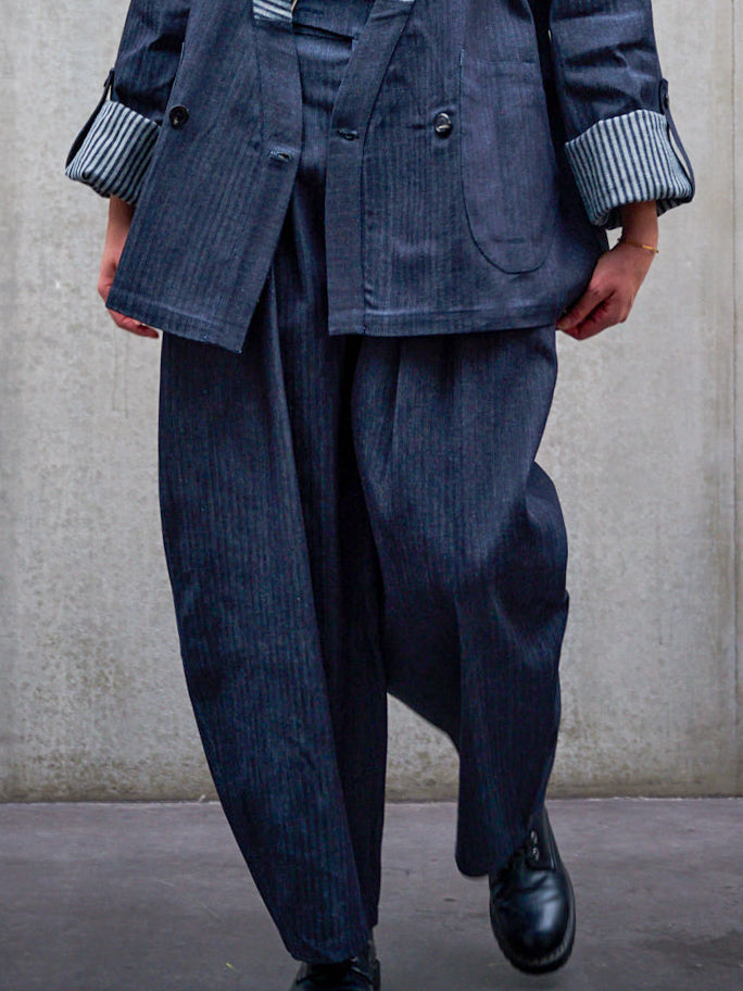 Pantalon circulaire Aïdama, coupe ballon oversize en denim japonais rayé. Porté par une mannequin femme et vu de face, zoomé sur les jambes.