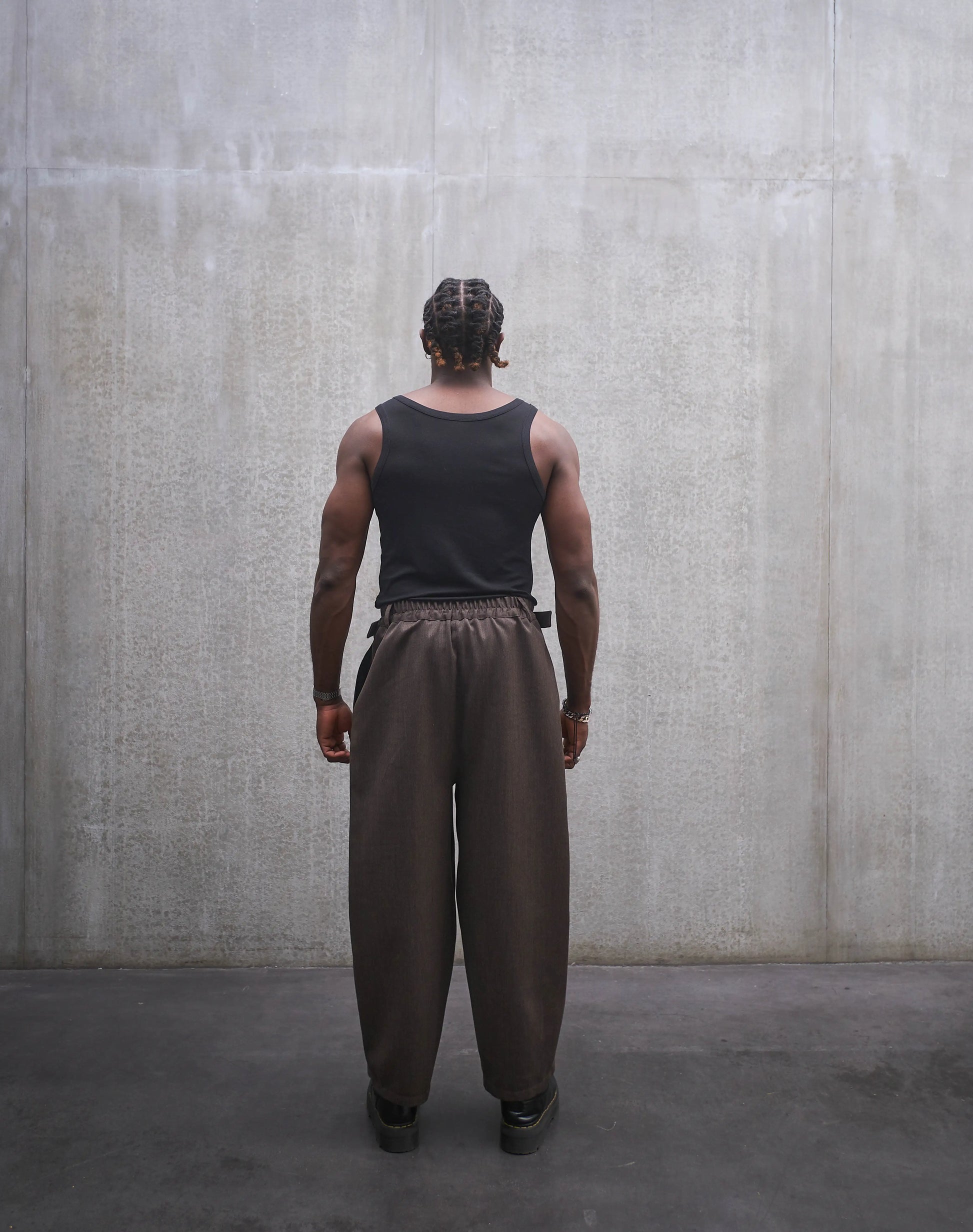 Pantalon circulaire Aïdama, coupe ballon en laine froide marron chiné. Porté par un mannequin homme et vu de dos.