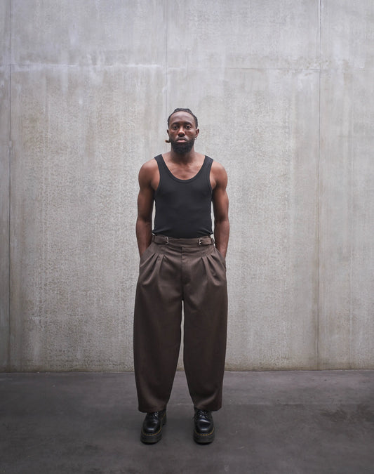 Pantalon circulaire Aïdama, coupe ballon en laine froide marron chiné. Porté par un mannequin homme et vu de face.