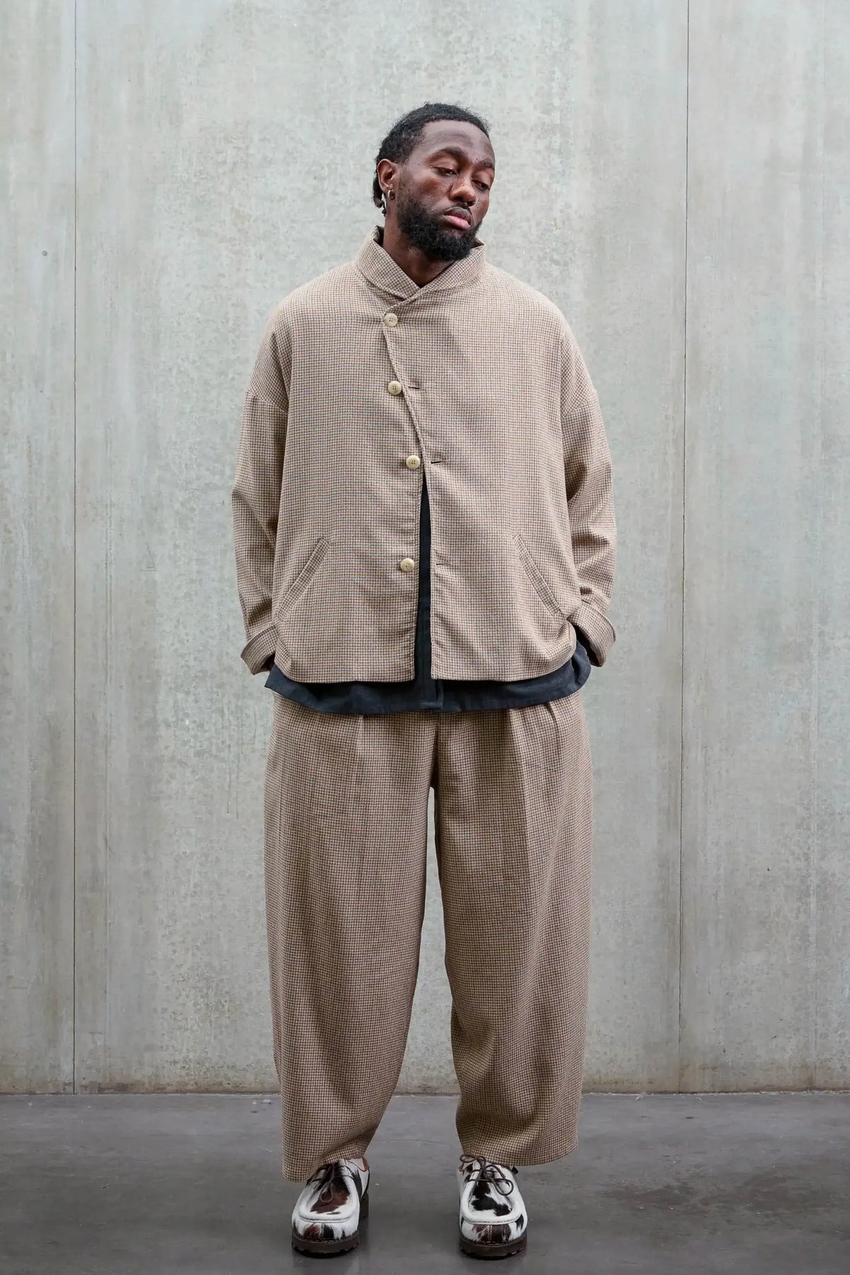 Veste oversize à col arrondi Aïdama, modèle Gunbai en laine marron à motif pied de poule. Portée fermée par un mannequin homme et vue de face.