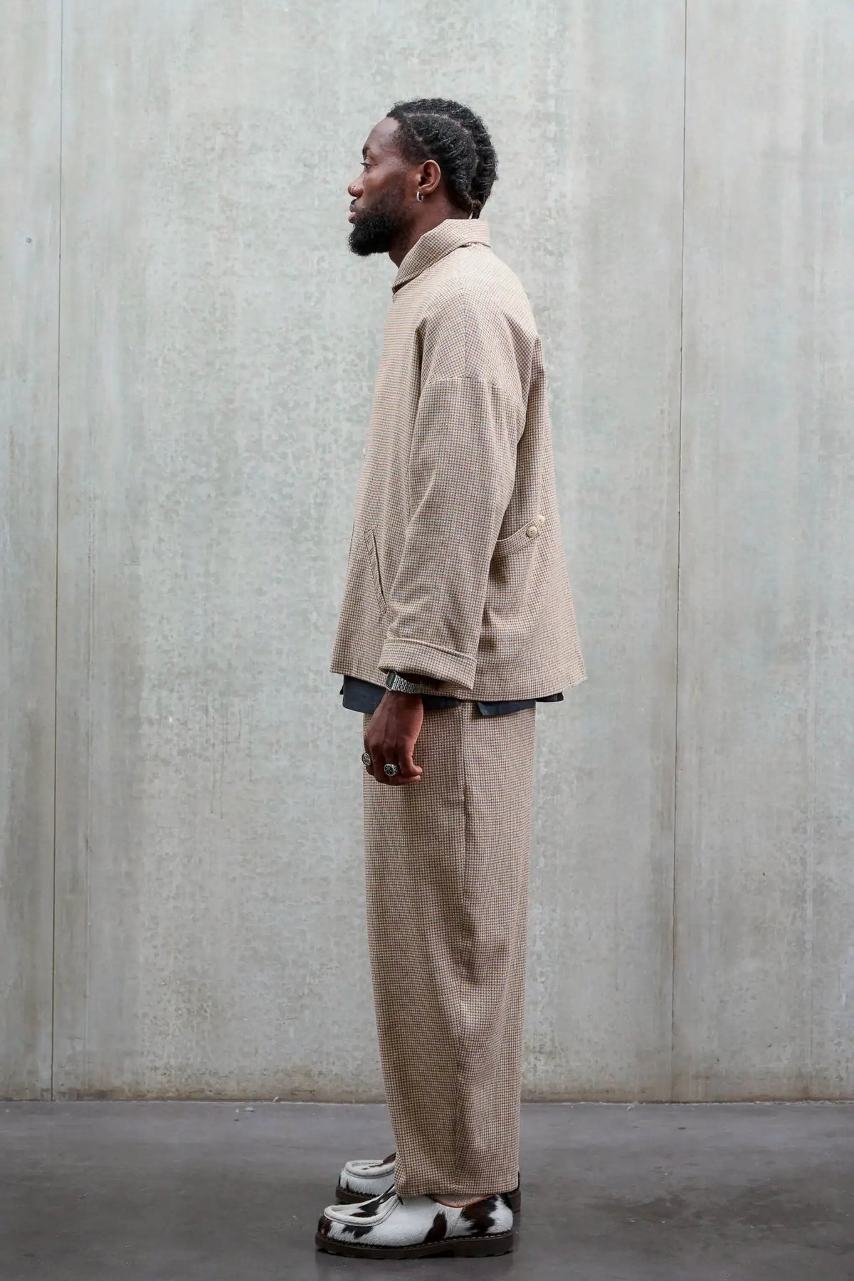 Veste oversize à col arrondi Aïdama, modèle Gunbai en laine marron à motif pied de poule. Portée fermée par un mannequin homme et vue de profil.